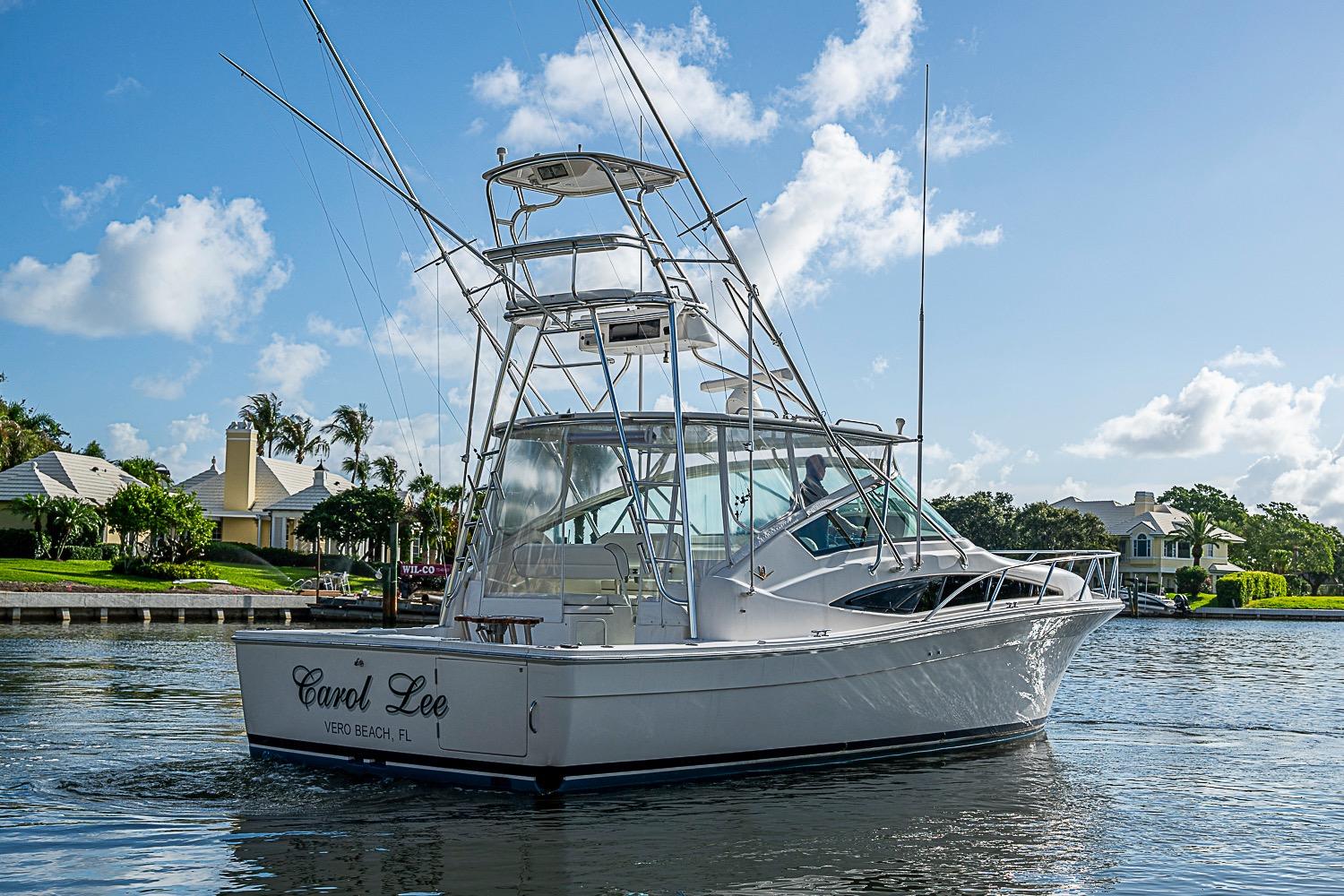 2008 Bertram 360 boat on water, clear sky, residential backdrop.