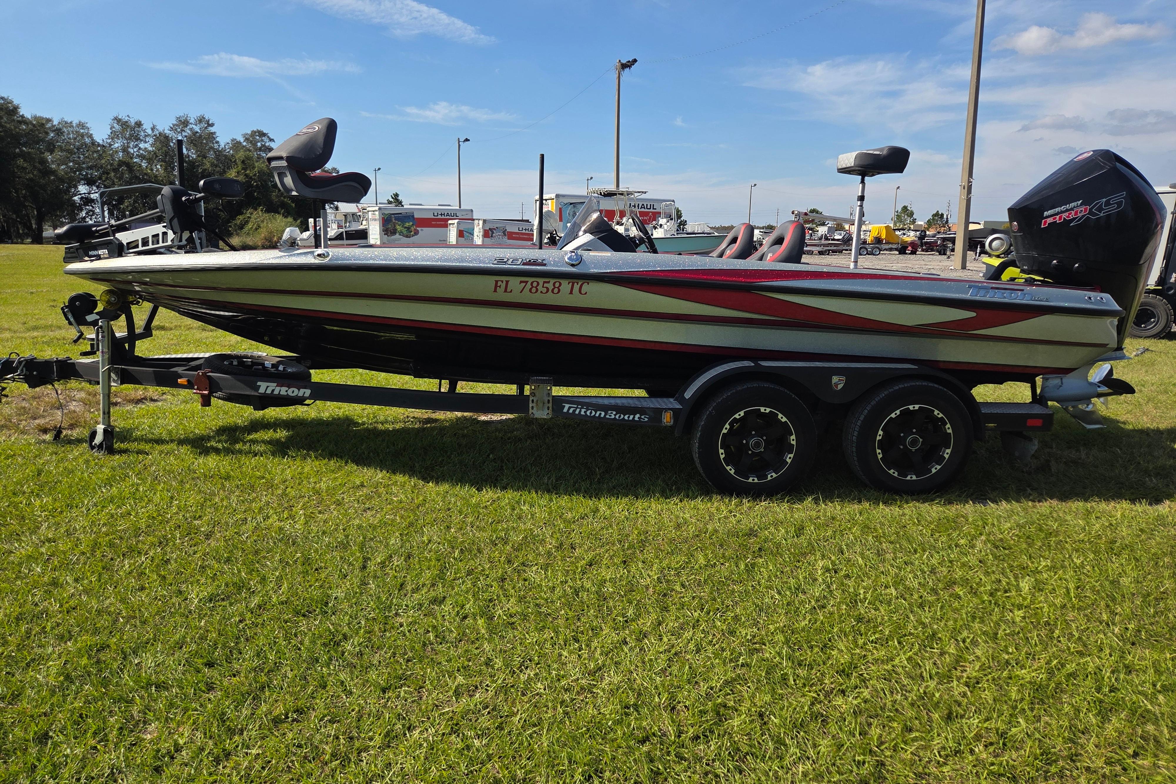2021 Triton 20 TrX boat on trailer, parked on grass under clear sky.