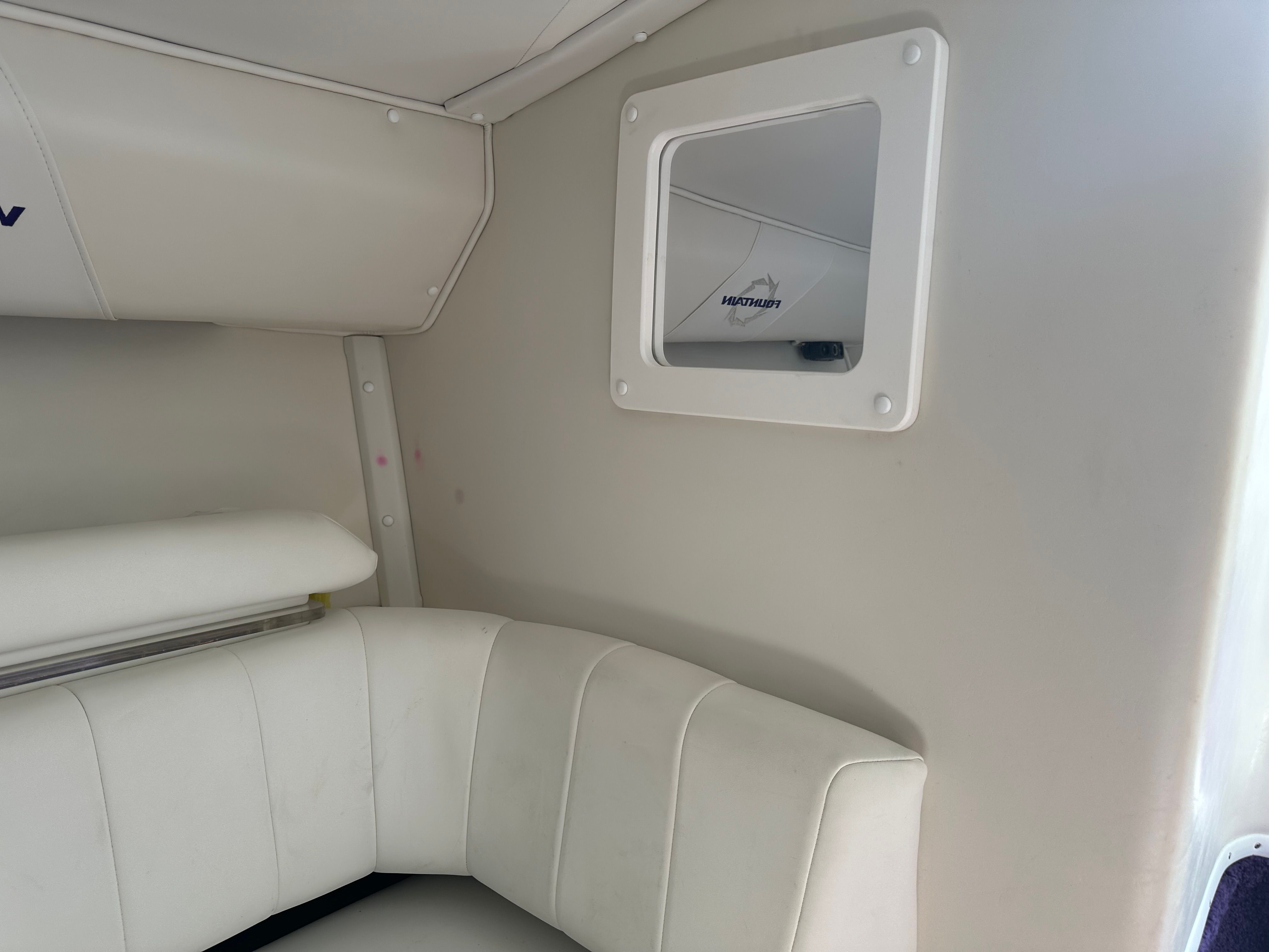 Interior of a 2006 Fountain 29 Fever with white upholstery and a small window.