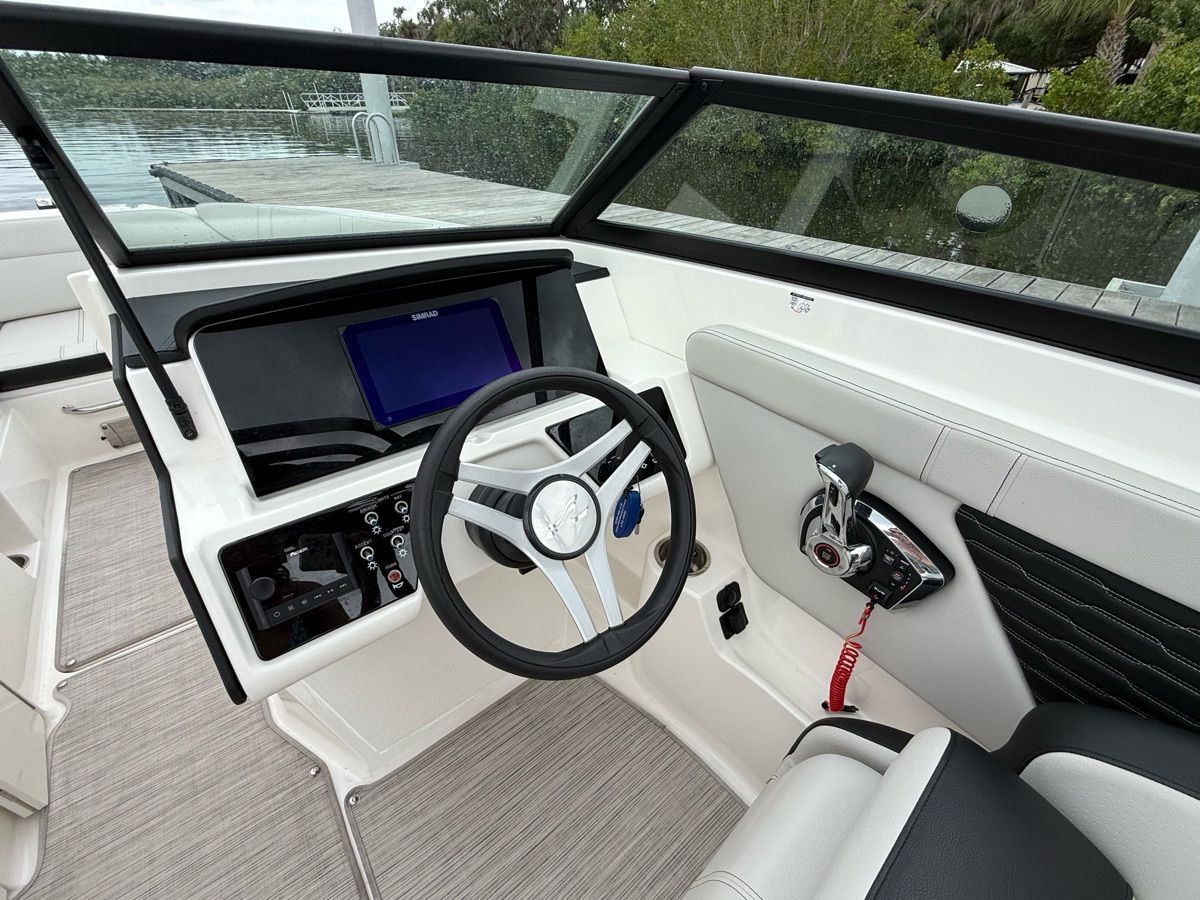 The image shows the cockpit of a 2024 Sea Ray SPX 230 Outboard with a modern helm.