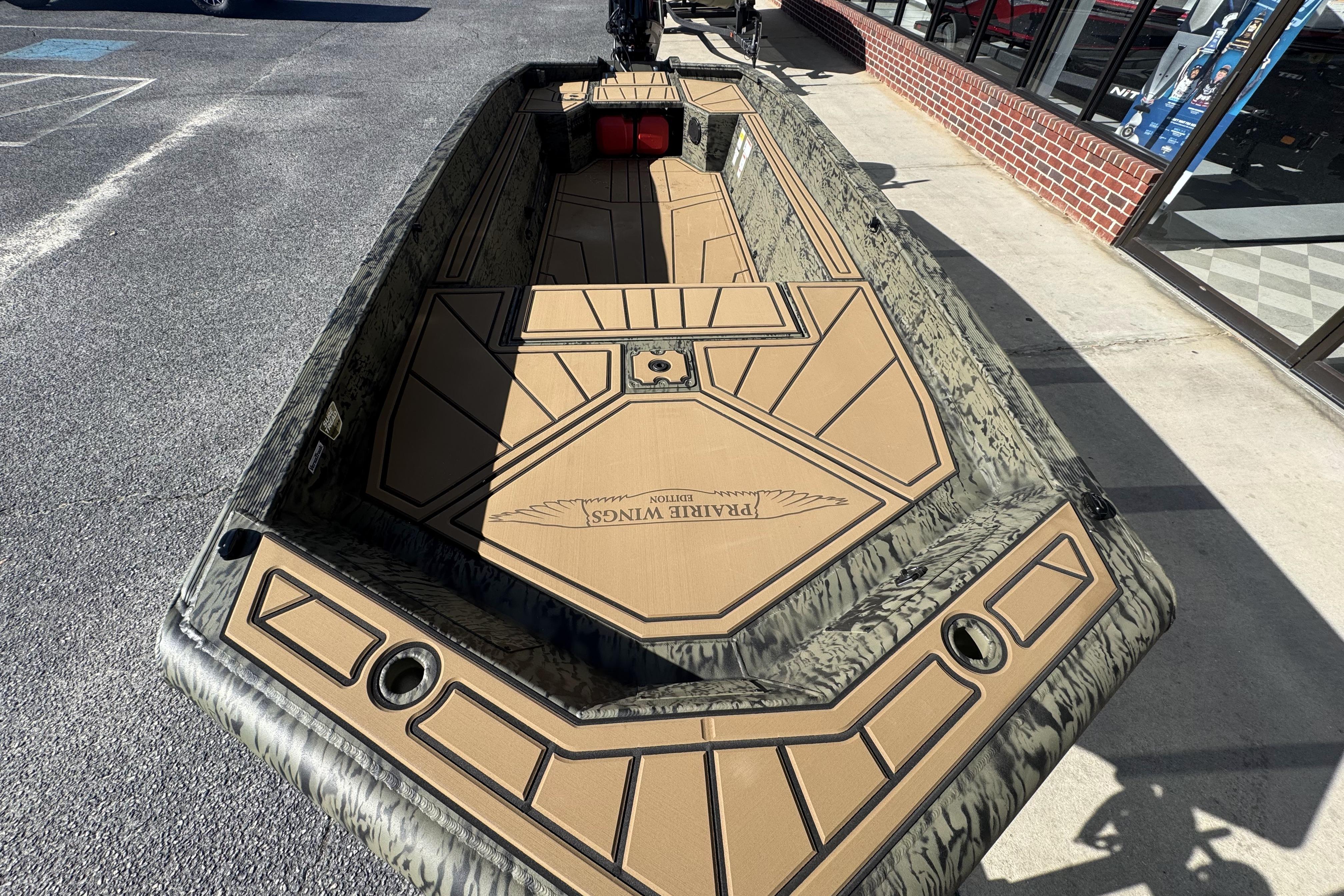 2026 Tracker Grizzly 1650 T Prairie Wings Edition boat with camouflage design on display.