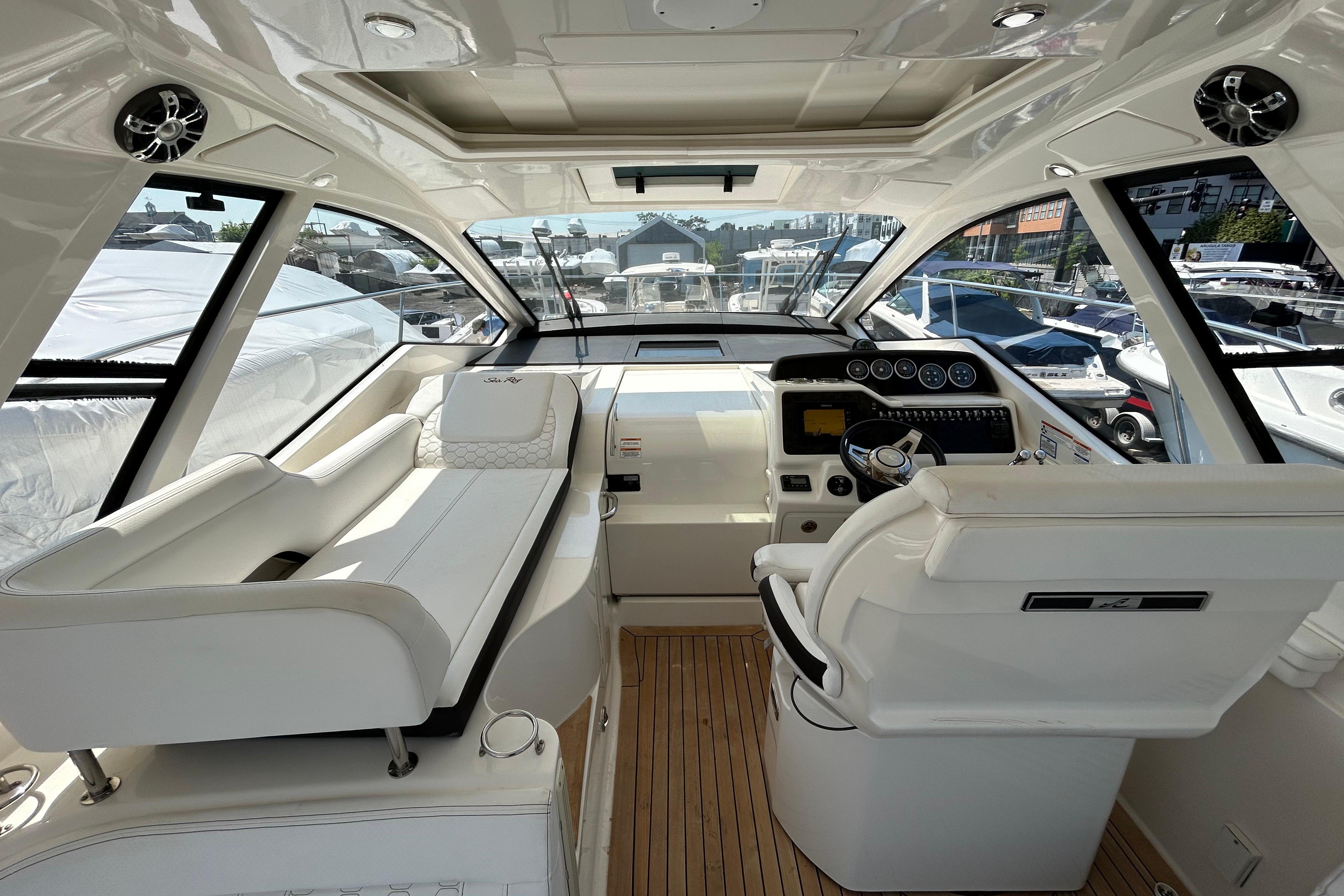 Interior of 2019 Sea Ray Sundancer 350 yacht, featuring sleek white seating and modern controls.