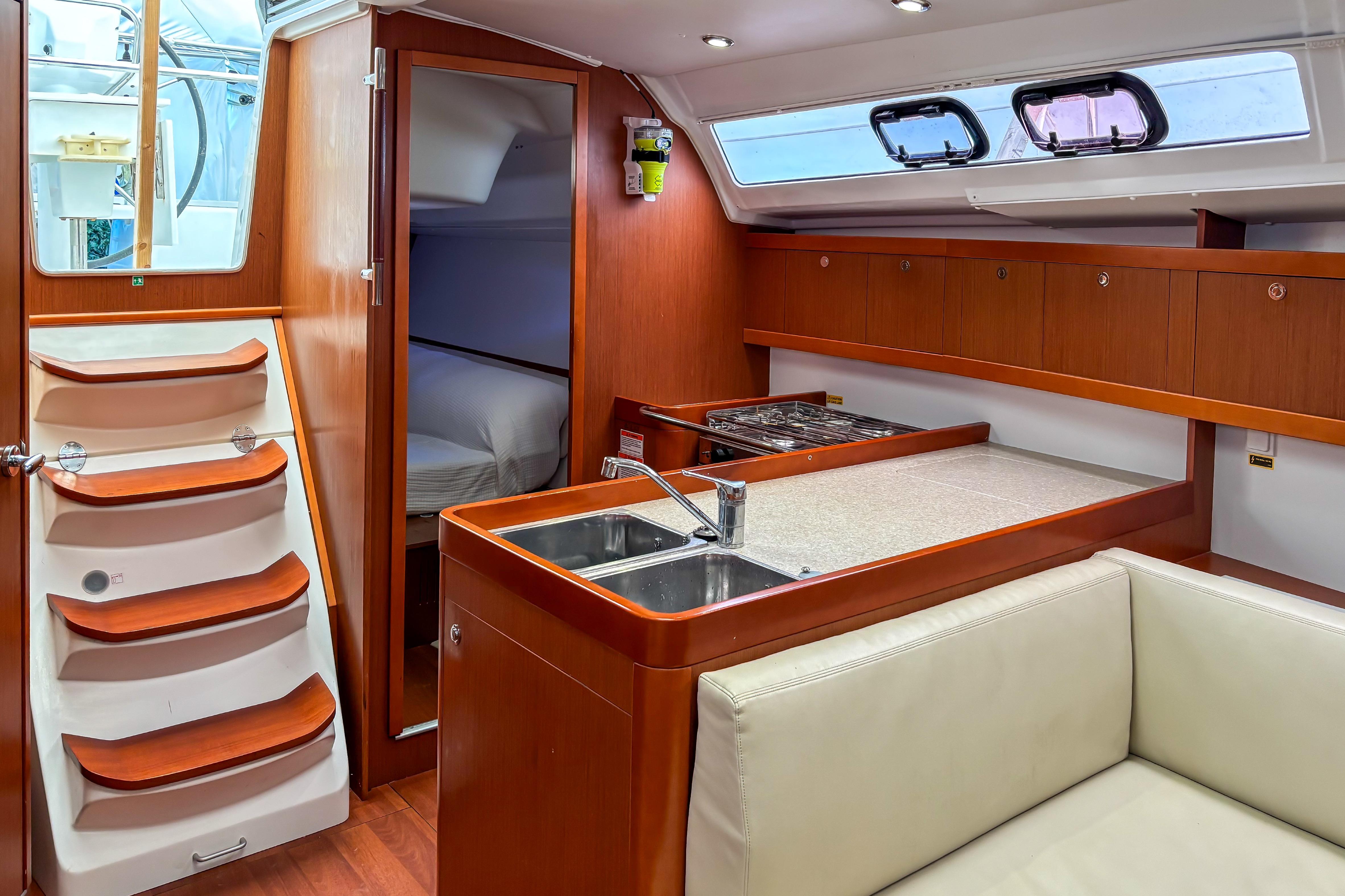 Interior of 2015 Beneteau Oceanis 37 yacht with modern kitchen and cozy cabin.