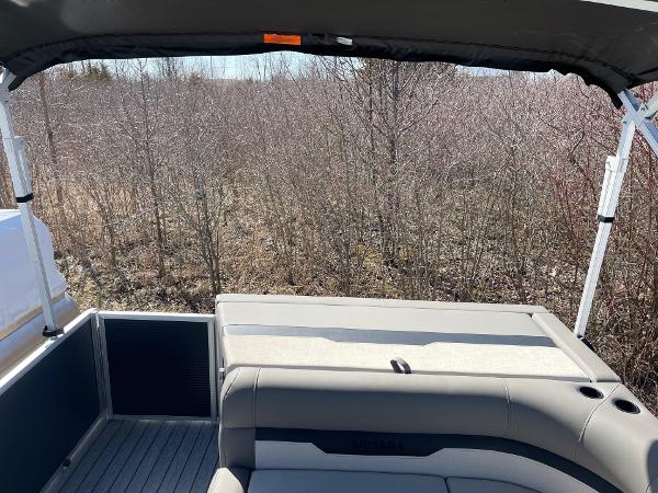 2025 Armada Saphir 23CR boat interior with seating, surrounded by bare trees.