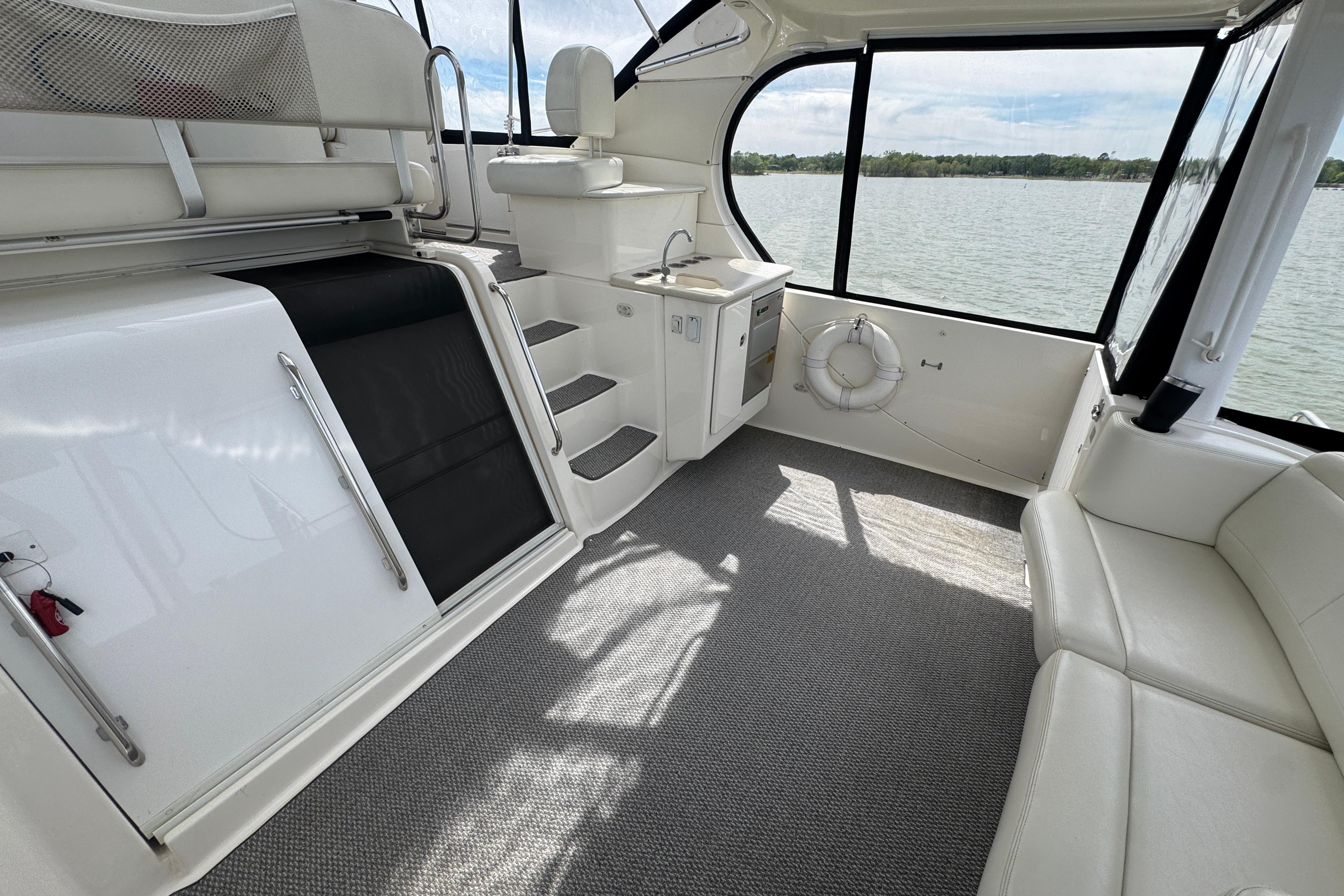 Interior of 2003 Silverton 39 Motor Yacht with seating, kitchenette, and lake view.