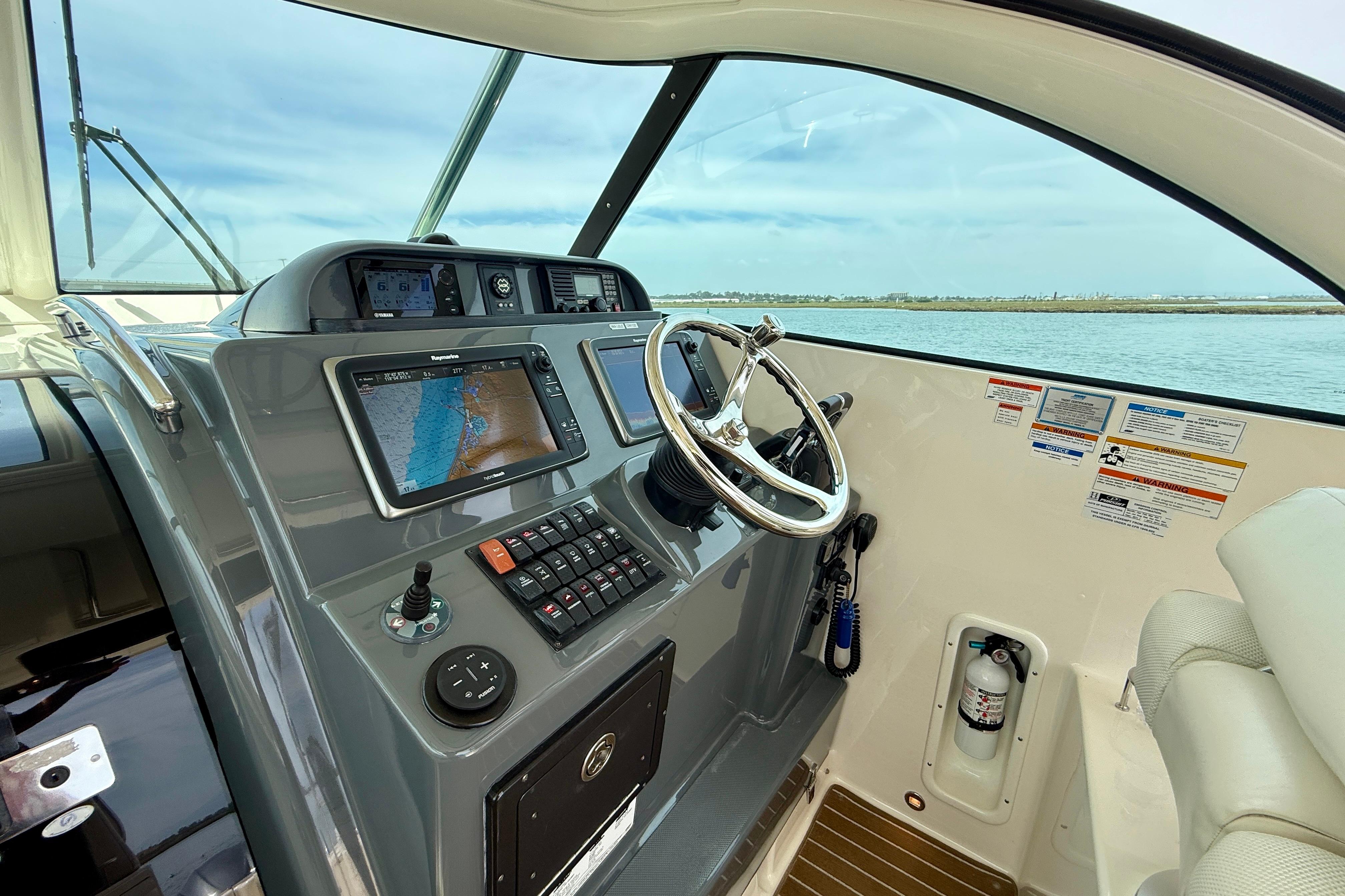 Helm of 2012 Pursuit OS 345 Offshore boat with navigation controls and steering wheel.