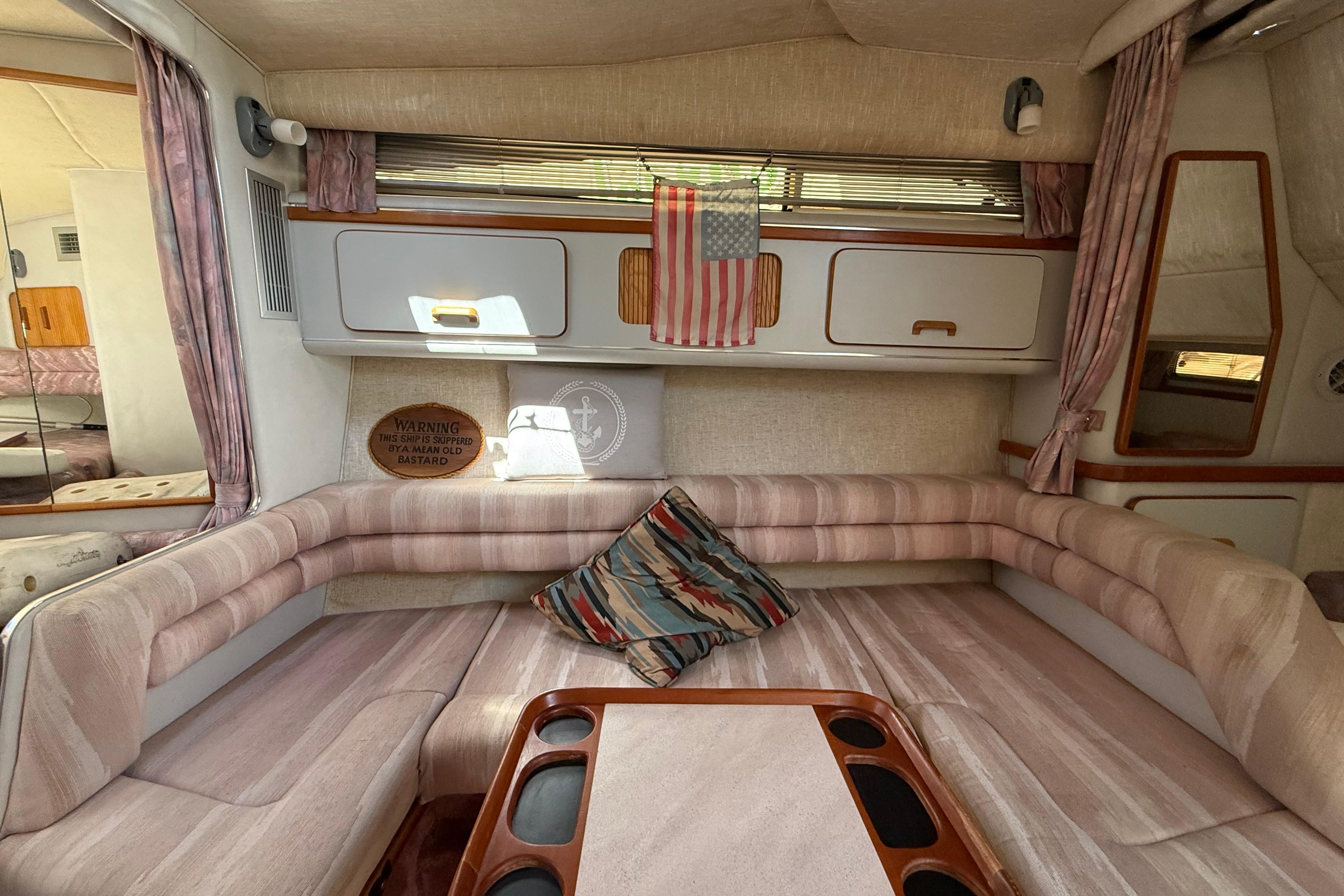 Interior of 1990 Sea Ray 310 Express Cruiser with cozy seating and decor.