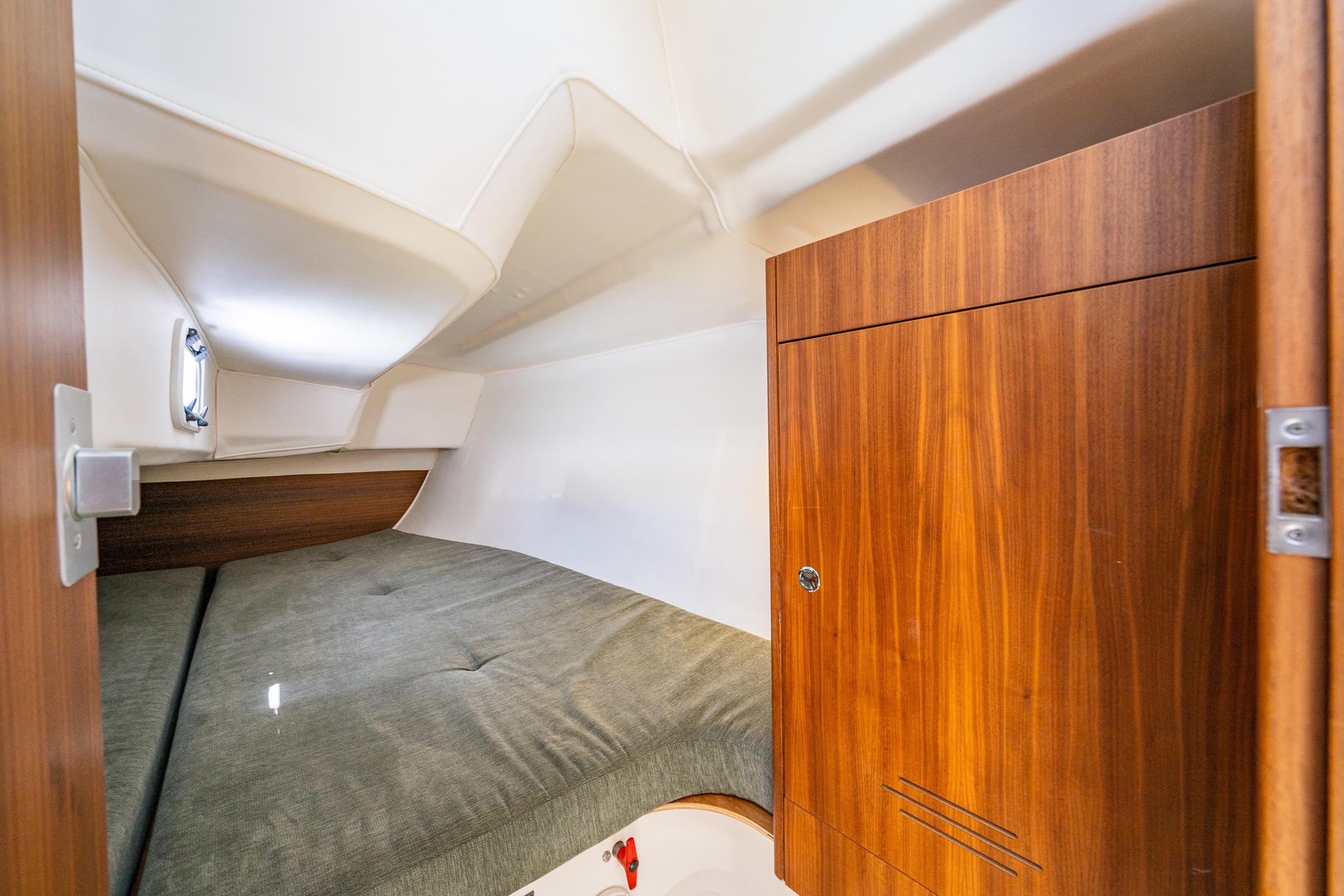 2018 J Boats J/97E cabin interior with wooden cabinetry and cozy sleeping area.