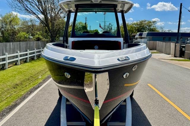 2026 Monterey Elite 25 OB boat on trailer, parked on a sunny road.