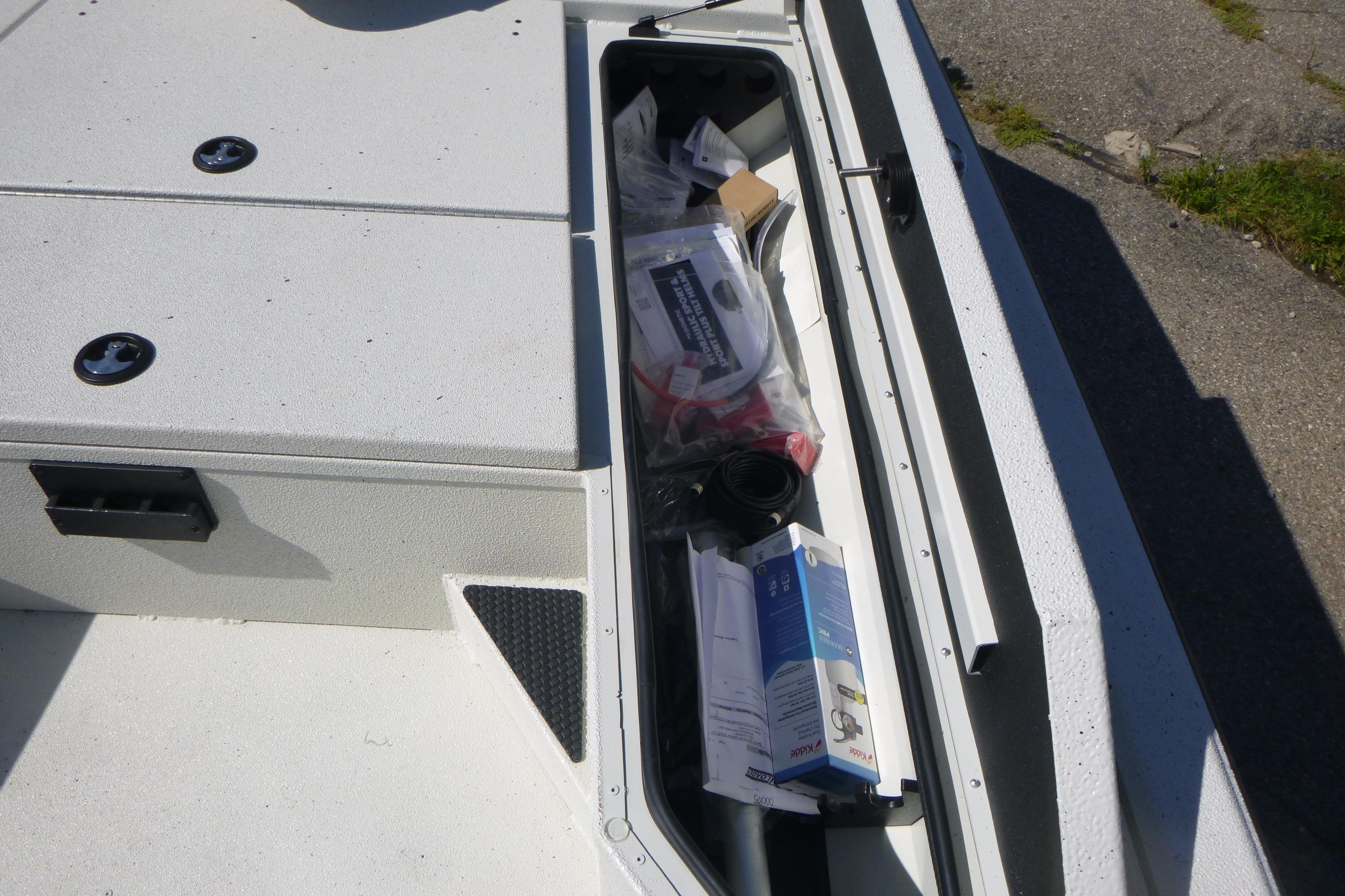 Storage compartment of 2025 Ranger RB210 boat with various items inside.