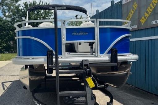 2026 Sun Tracker Fishin' Barge 20 DLX pontoon boat on trailer, blue exterior.