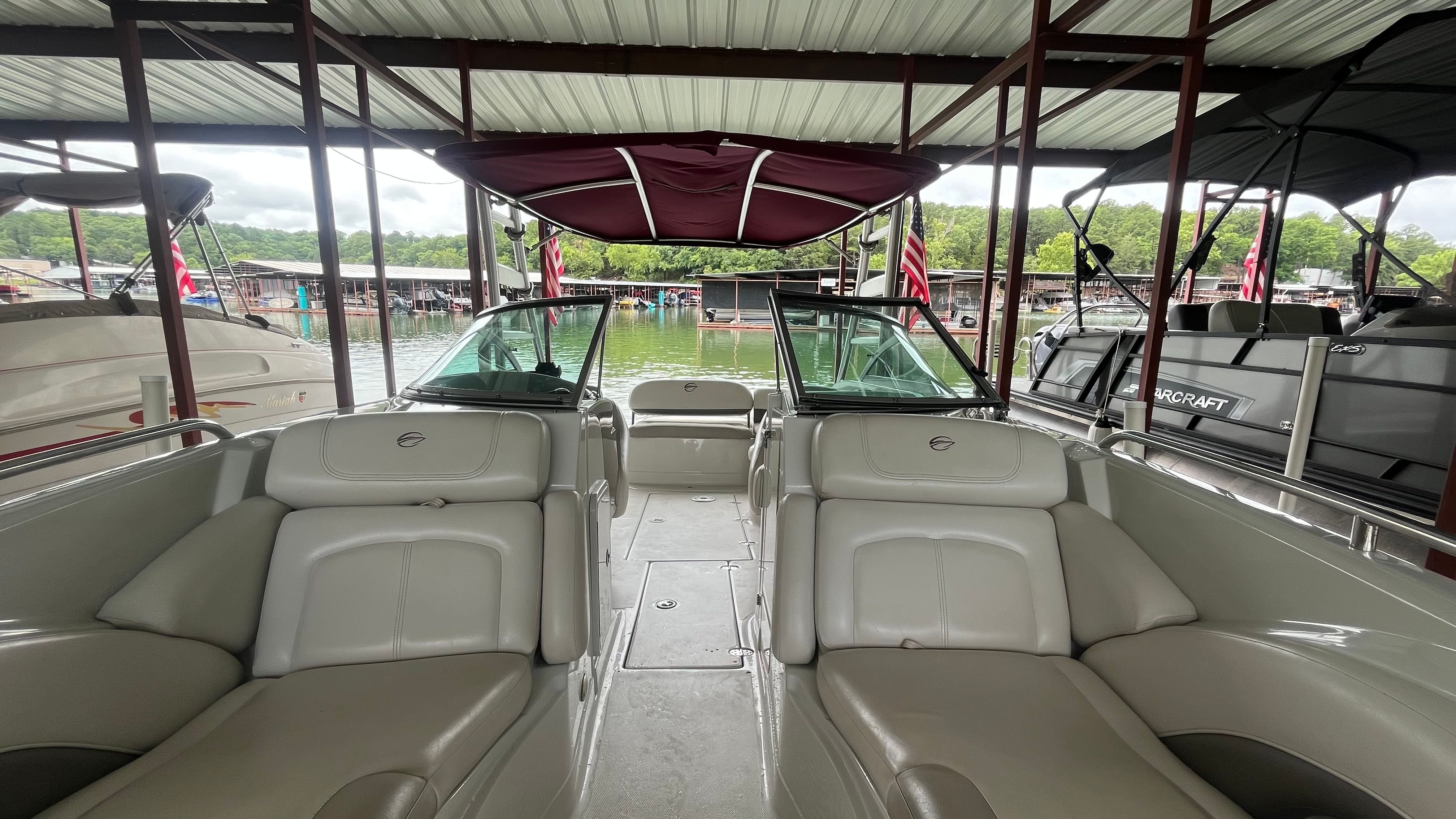 The image shows the interior of a 2008 Crownline 252EX boat docked under a covered area.