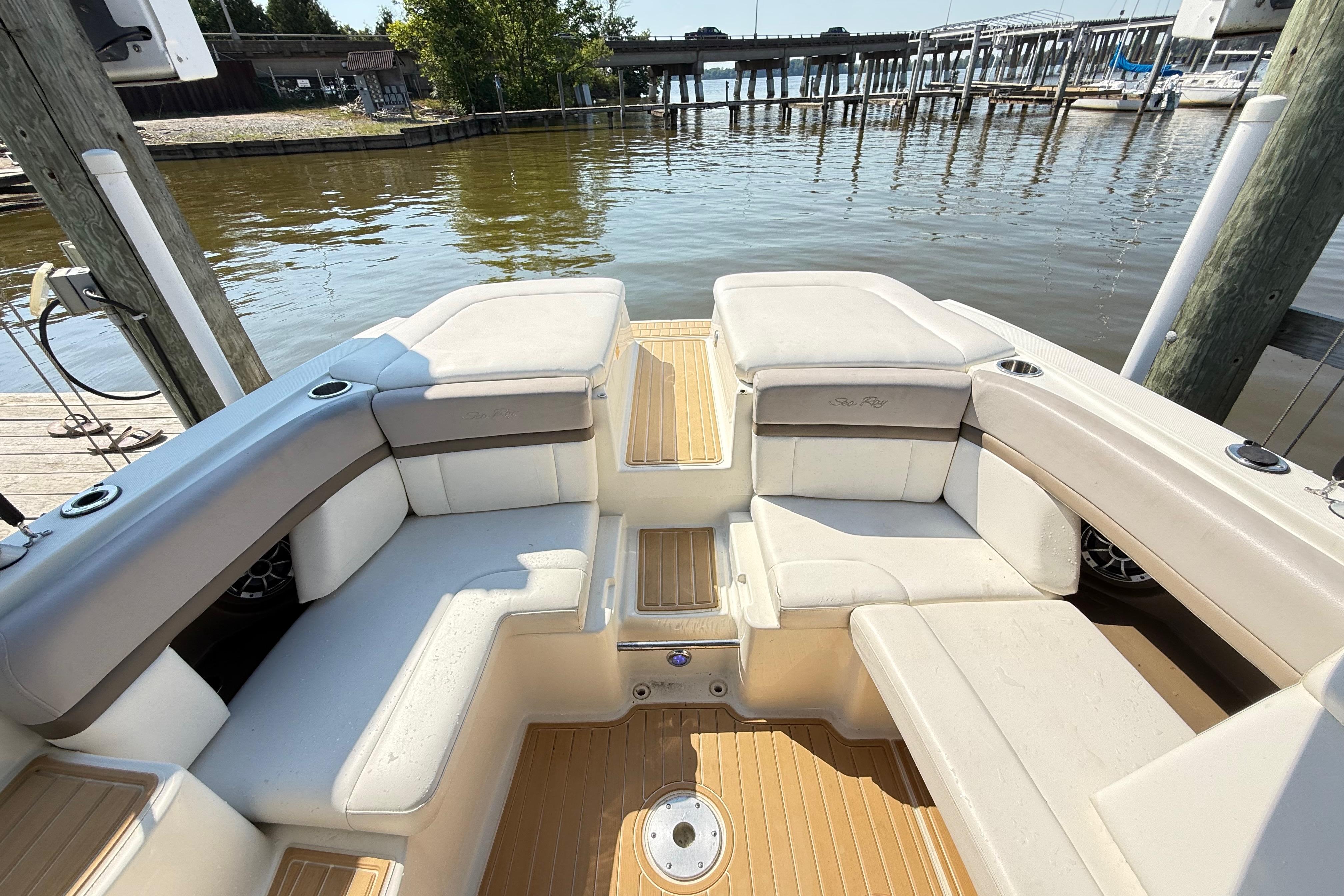 2011 Sea Ray 270 SLX boat interior with beige seating, docked by the water.