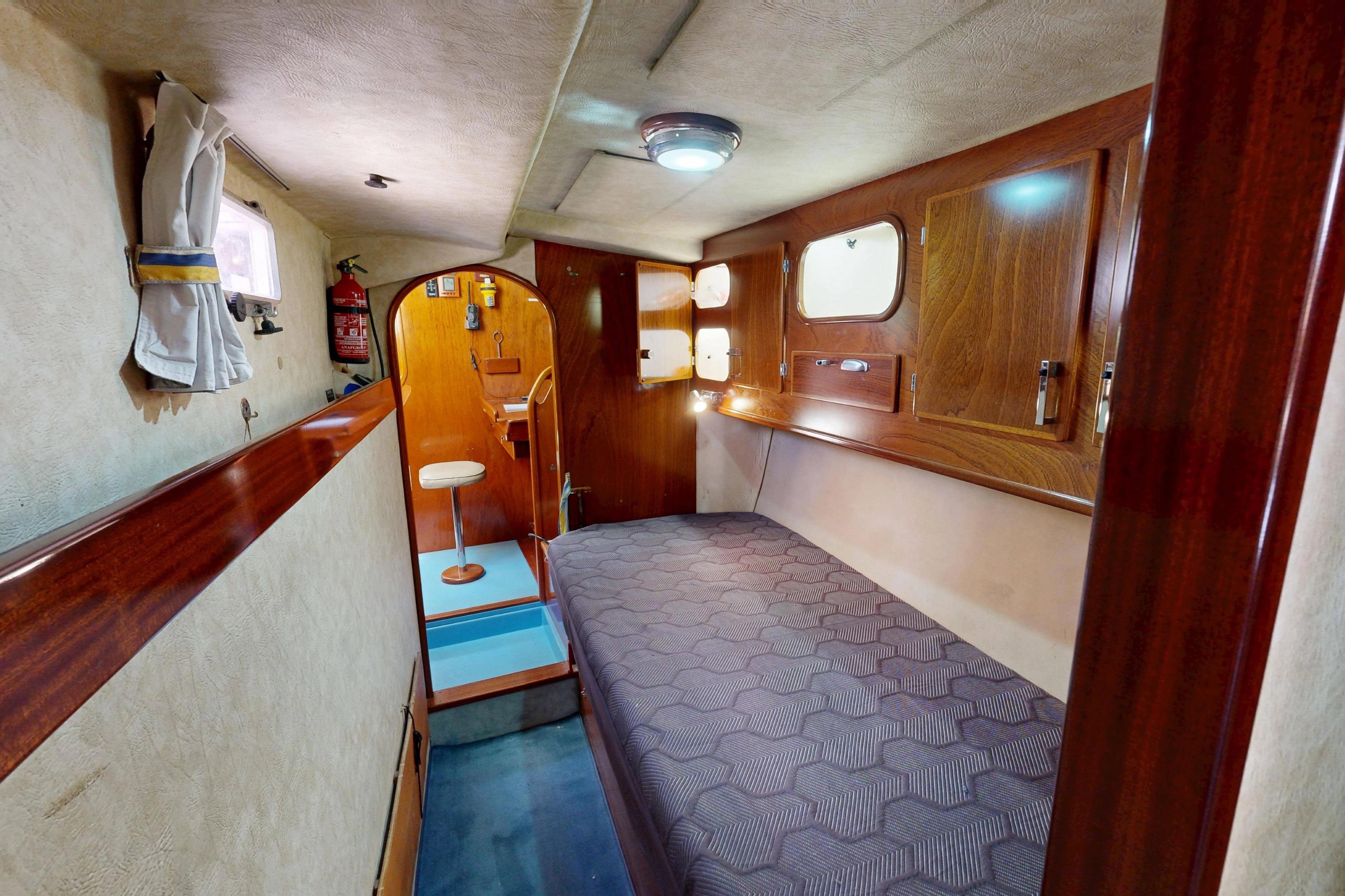 Cozy cabin interior of 1999 Amel Super Maramu 2000 yacht with wooden accents.