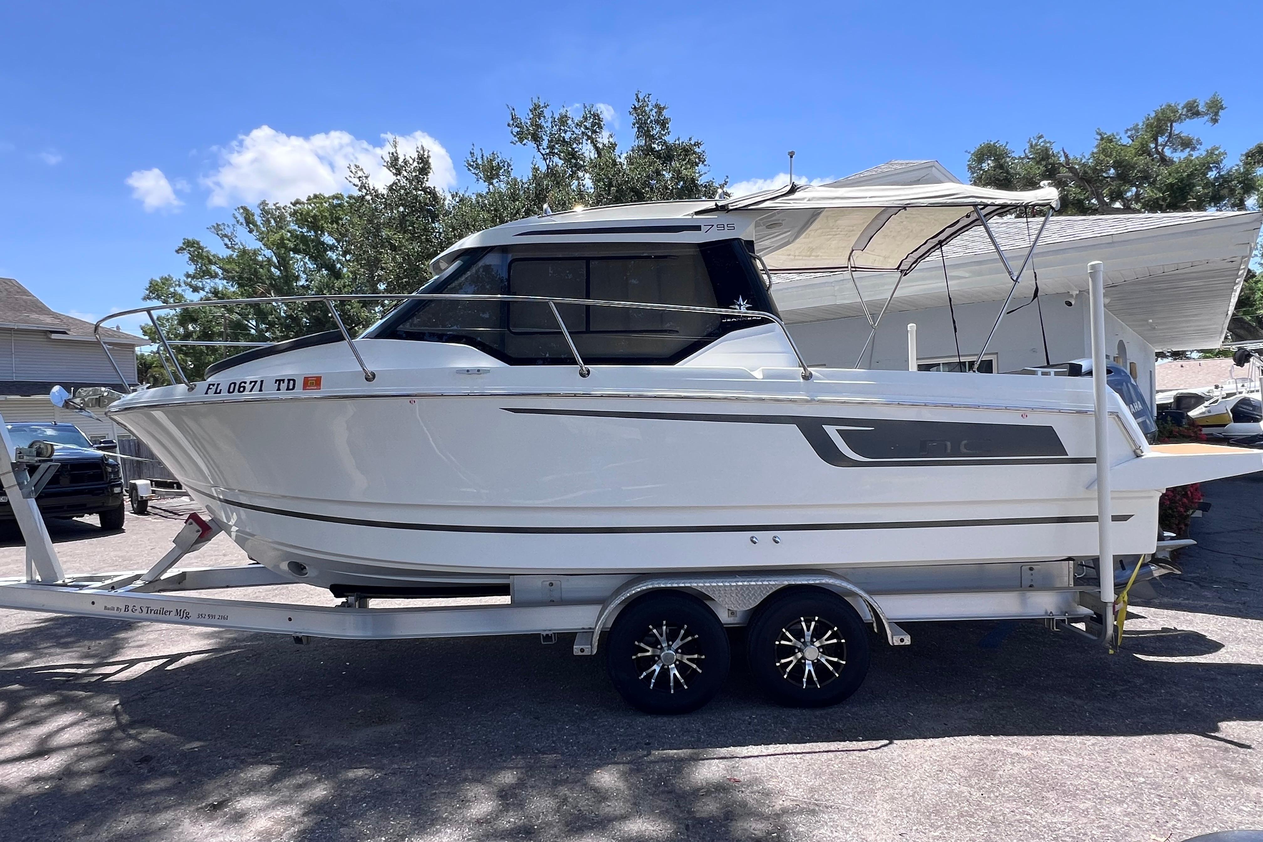 2021 Jeanneau NC Weekender 795 Series 2 boat on trailer, parked outdoors.