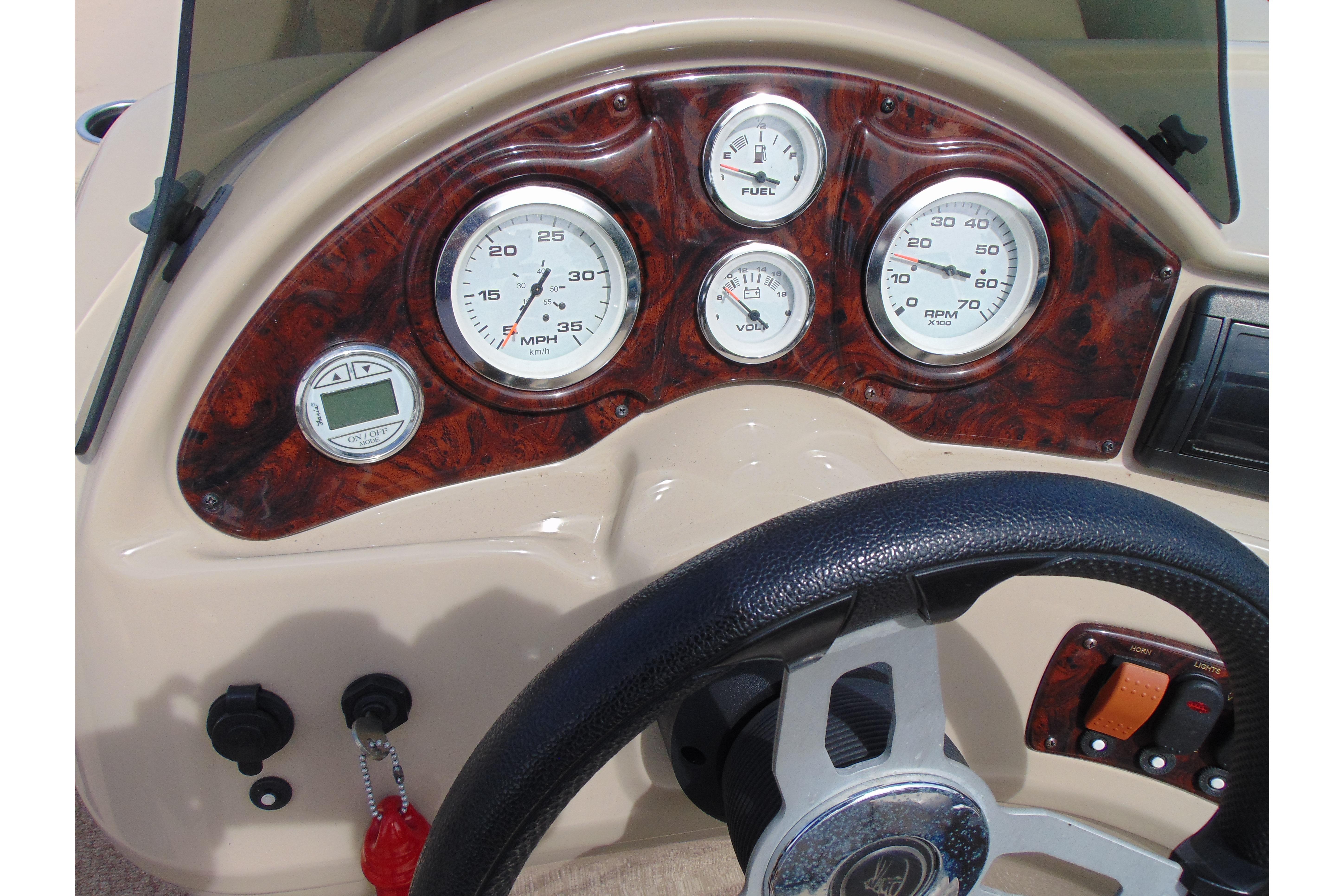 Dashboard of a 2016 Misty Harbor 245 Adventure CU boat with gauges and steering wheel.