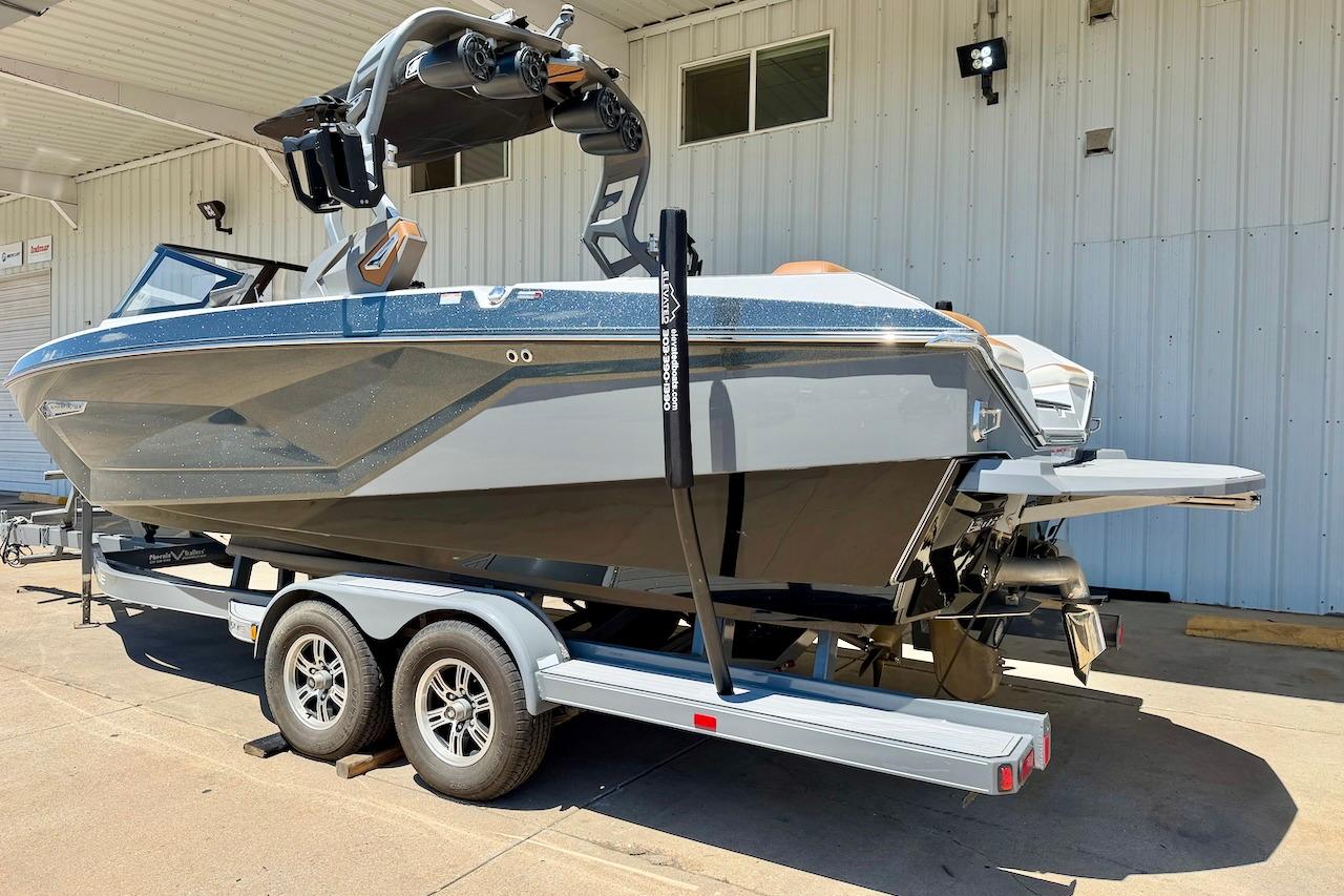 2021 Nautique Super Air Nautique G23 boat on trailer, parked outside a building.