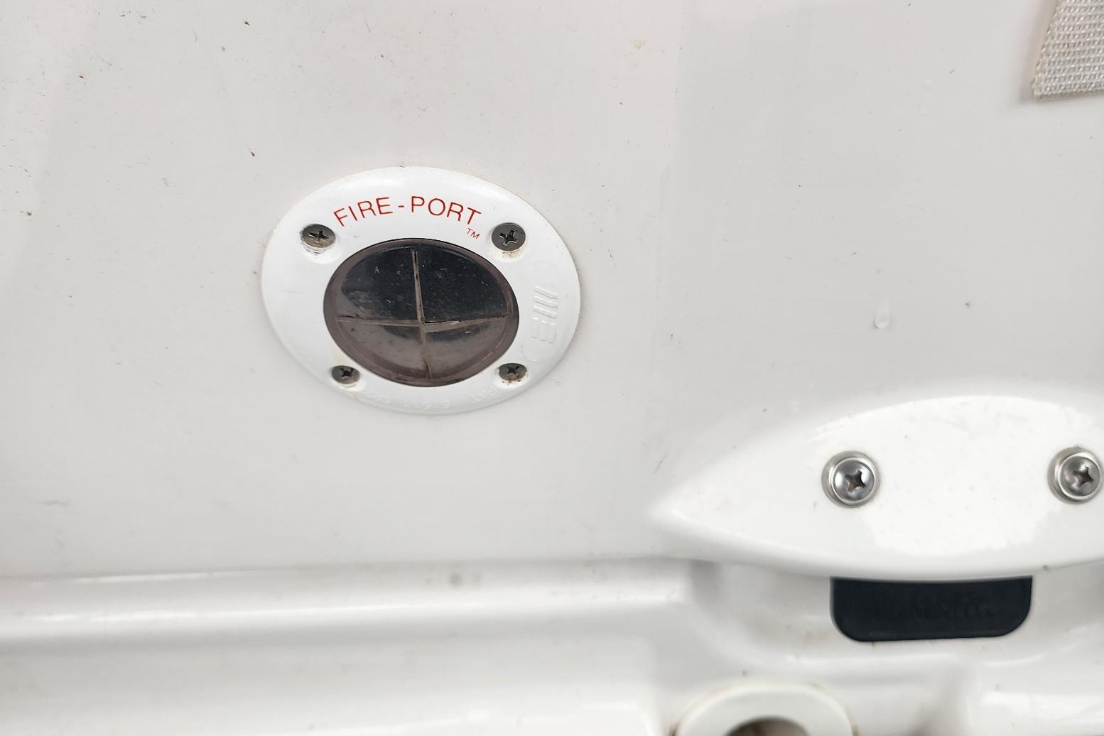 Fire-port on 2015 Yamaha Boats 212X, white surface with screws and label.