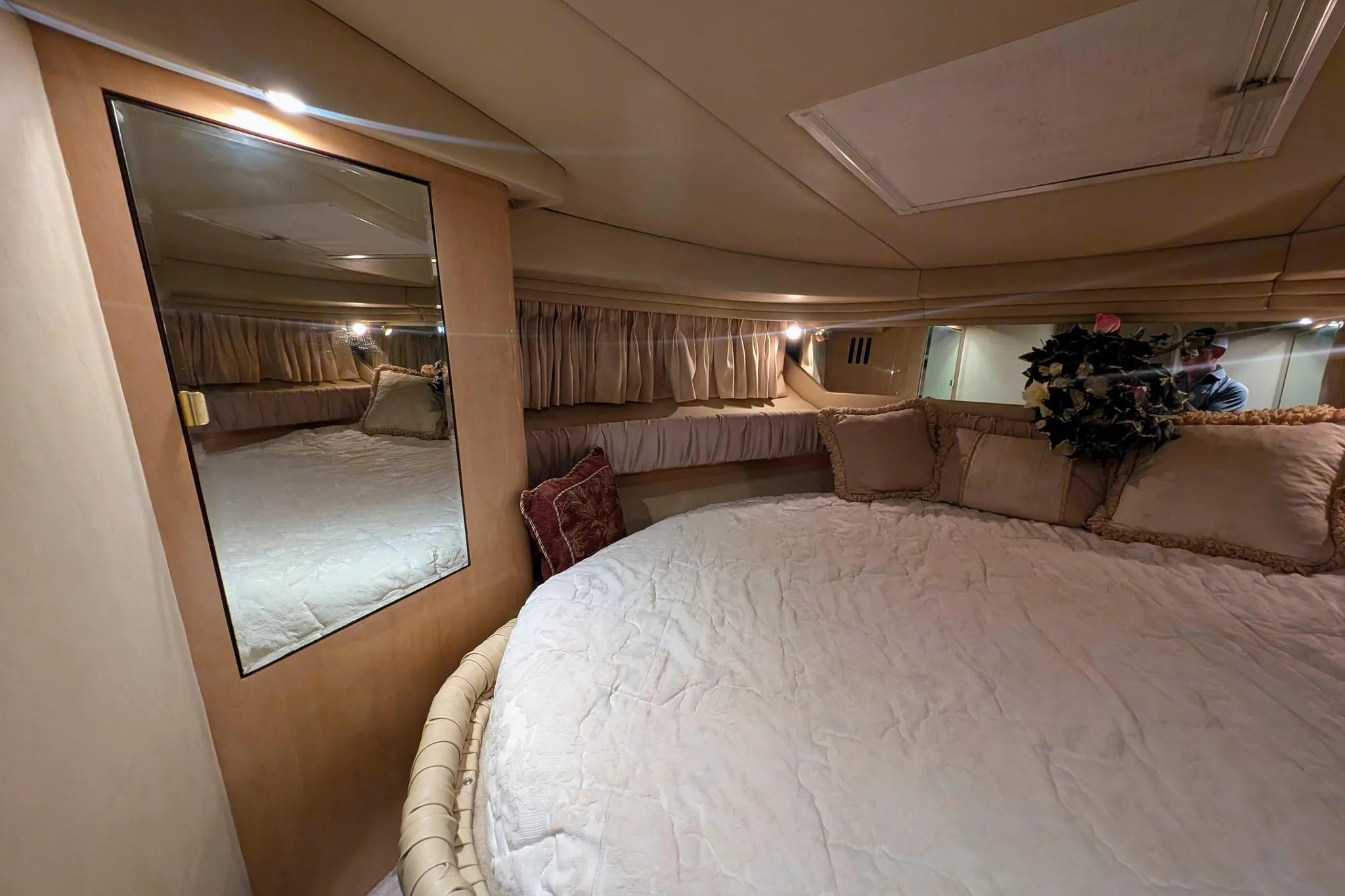 Luxurious interior cabin of 2000 Sea Ray 380 Sundancer yacht with cozy bedding.