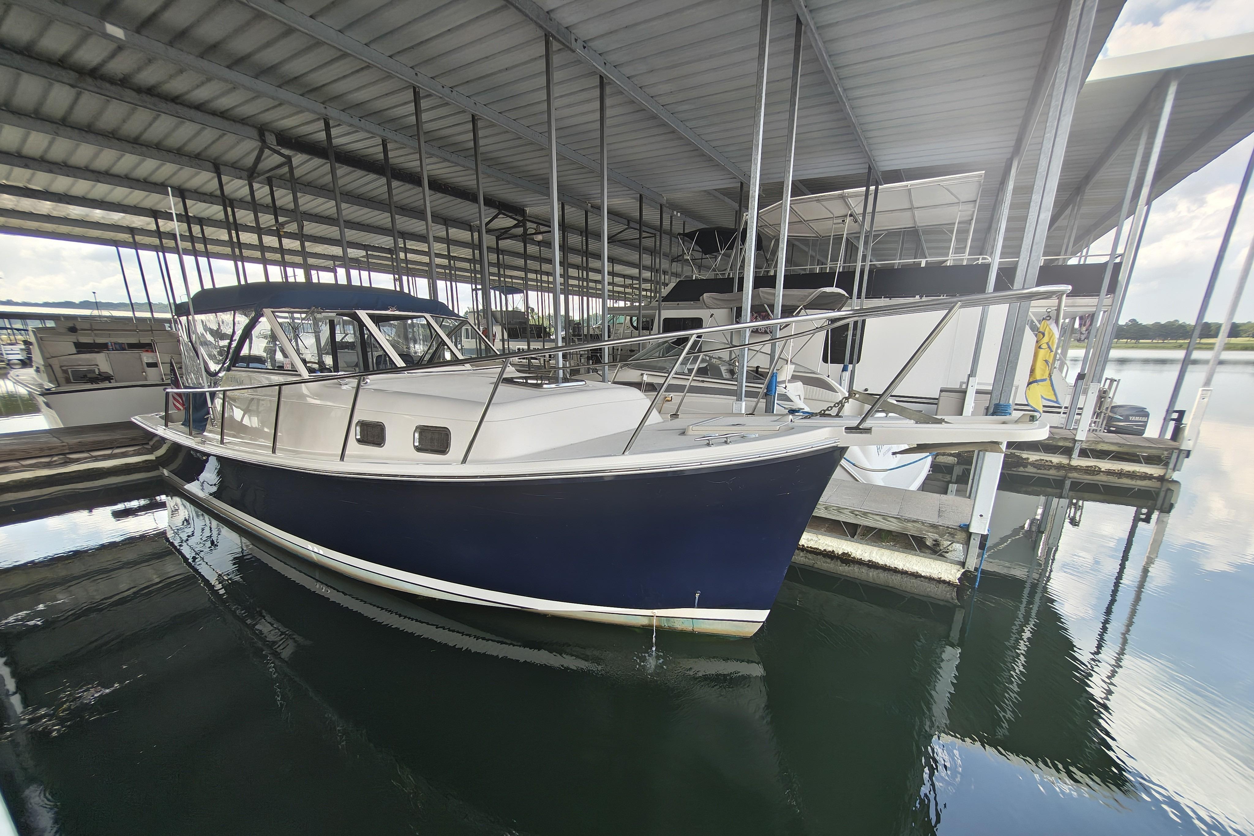 2003 Mainship Pilot 30-II boat docked in a covered marina.