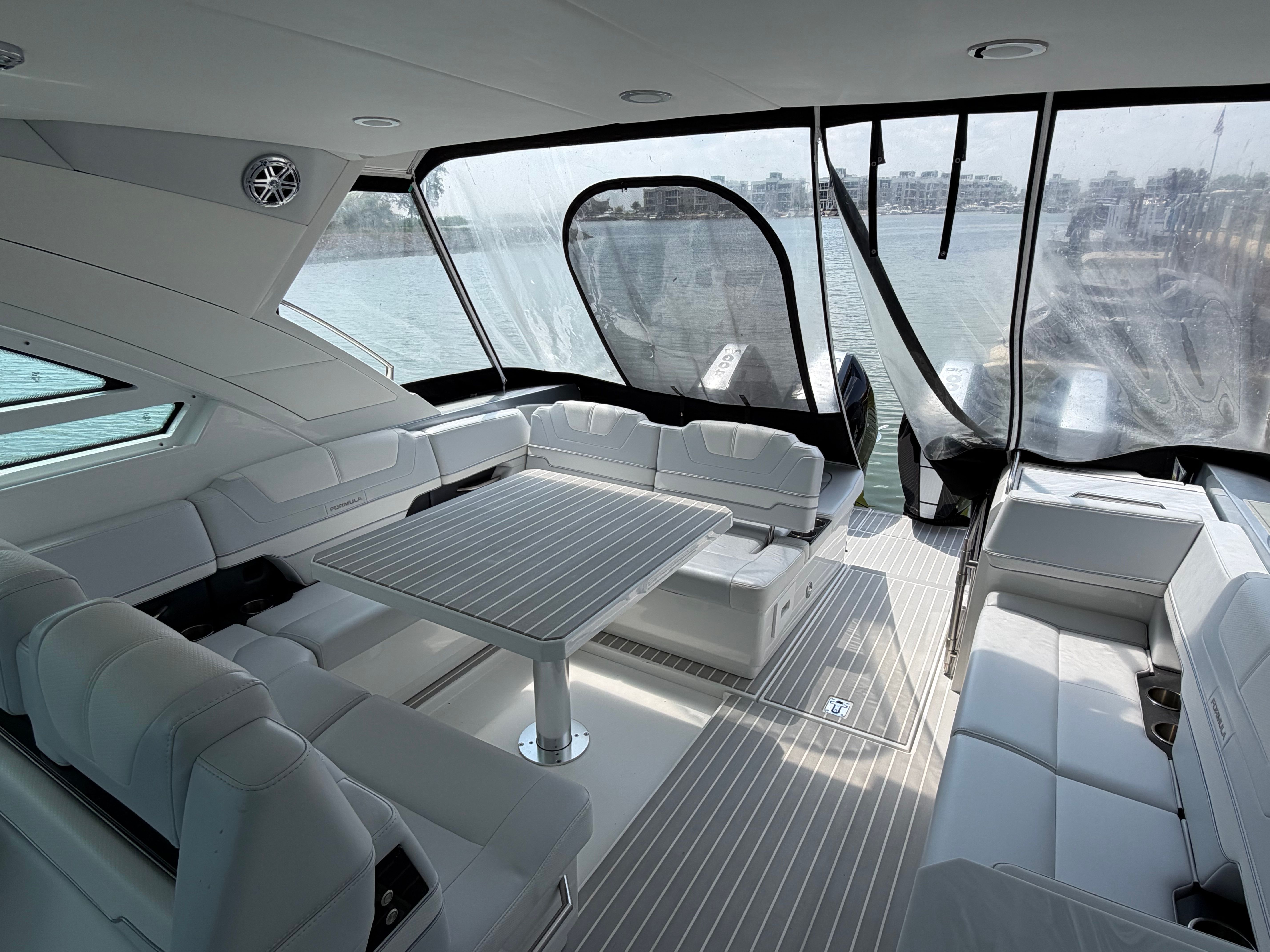 The image shows the interior of a 2023 Formula 400 Super Sport Crossover with sleek white seating and a table.