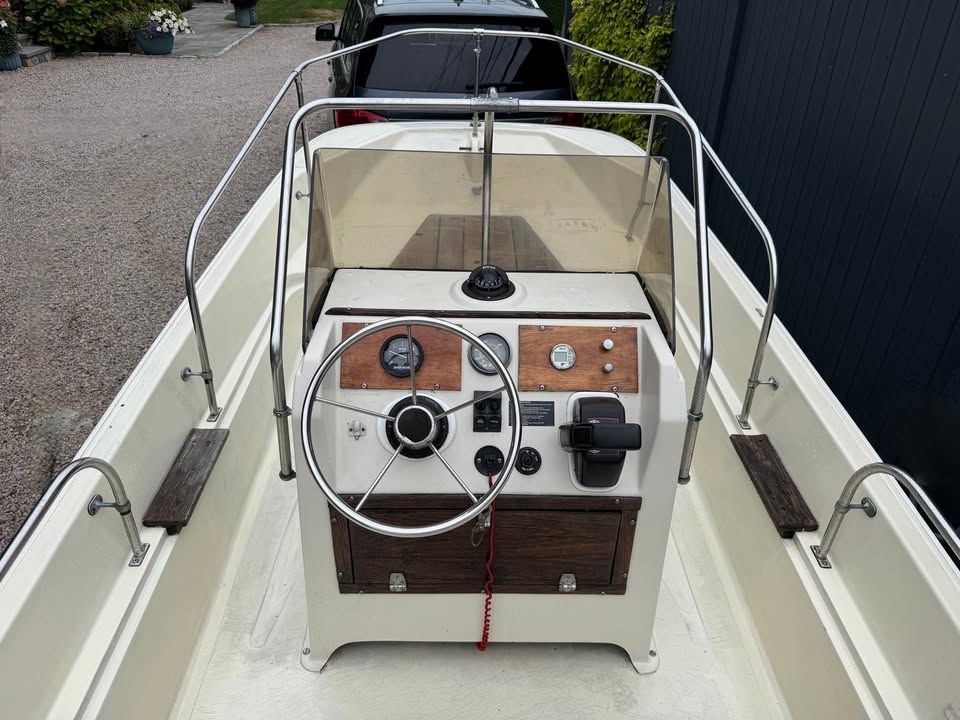The image shows the cockpit of a 1976 Boston Whaler 17 Montauk with a classic helm.