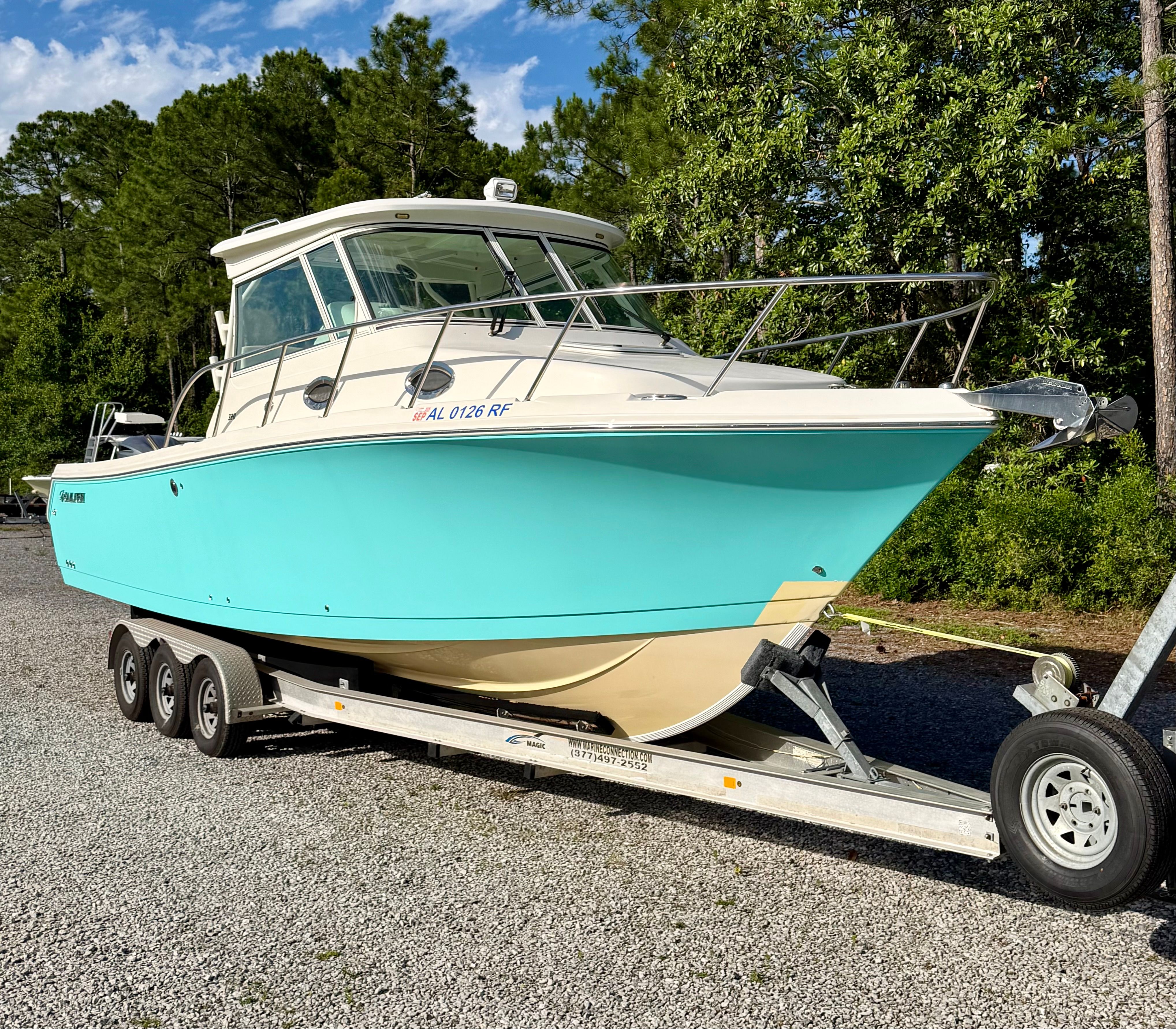 2014 Sailfish 320 Express boat on trailer outdoors.