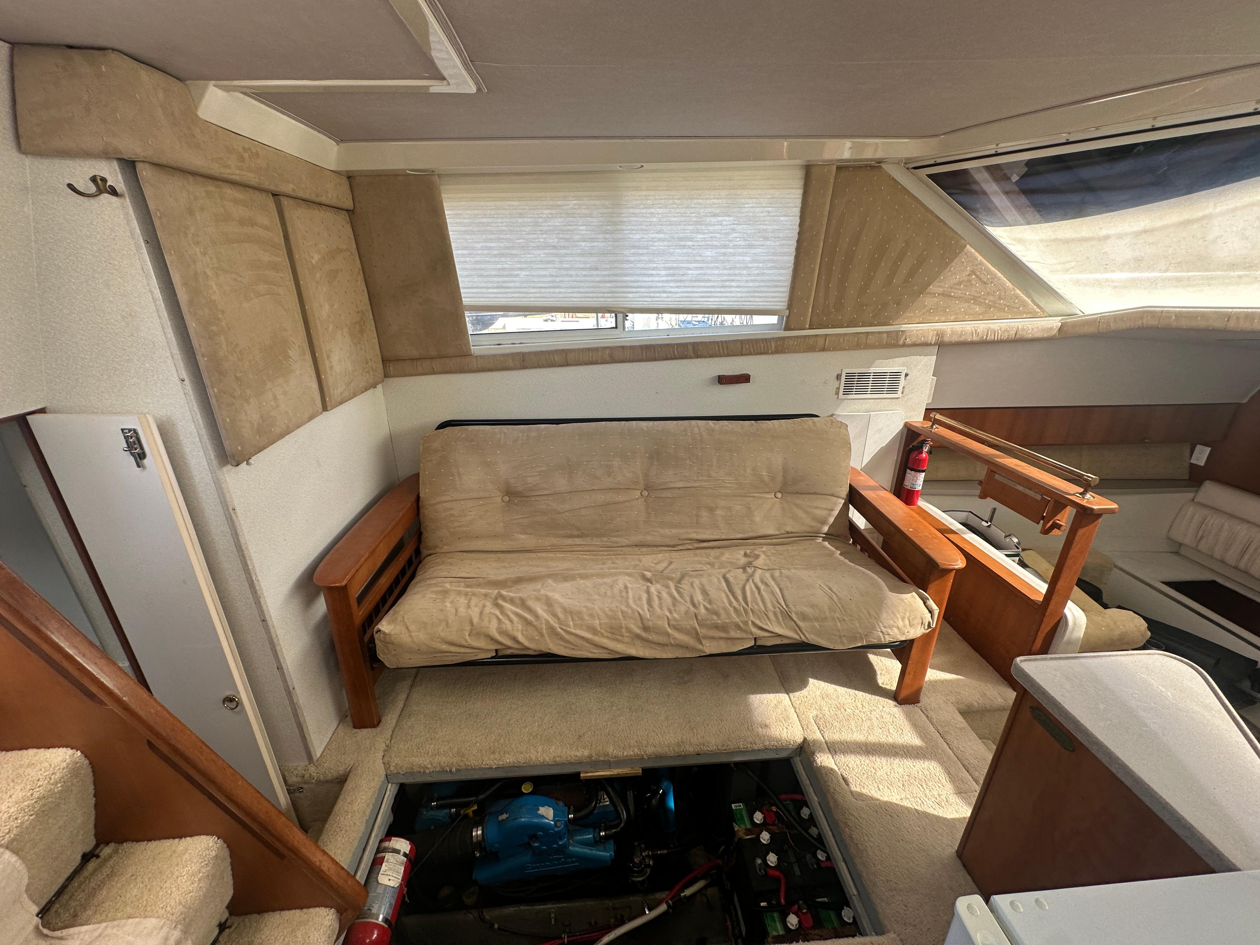 Interior of 1994 Silverton 34 Aft Cabin Motor Yacht with beige seating and engine access.