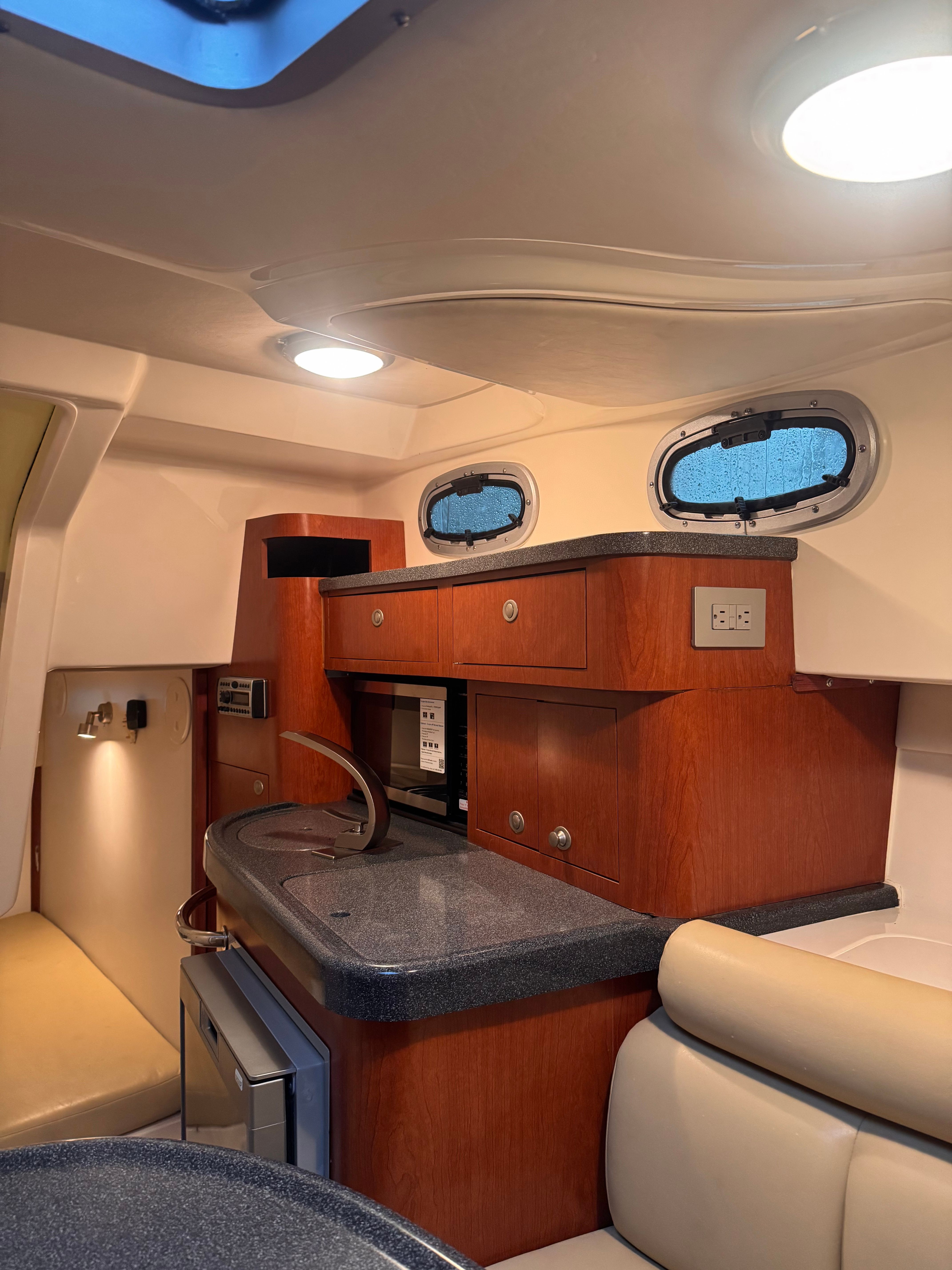 Interior of the 2006 Boston Whaler 305 Conquest with kitchenette and seating area.