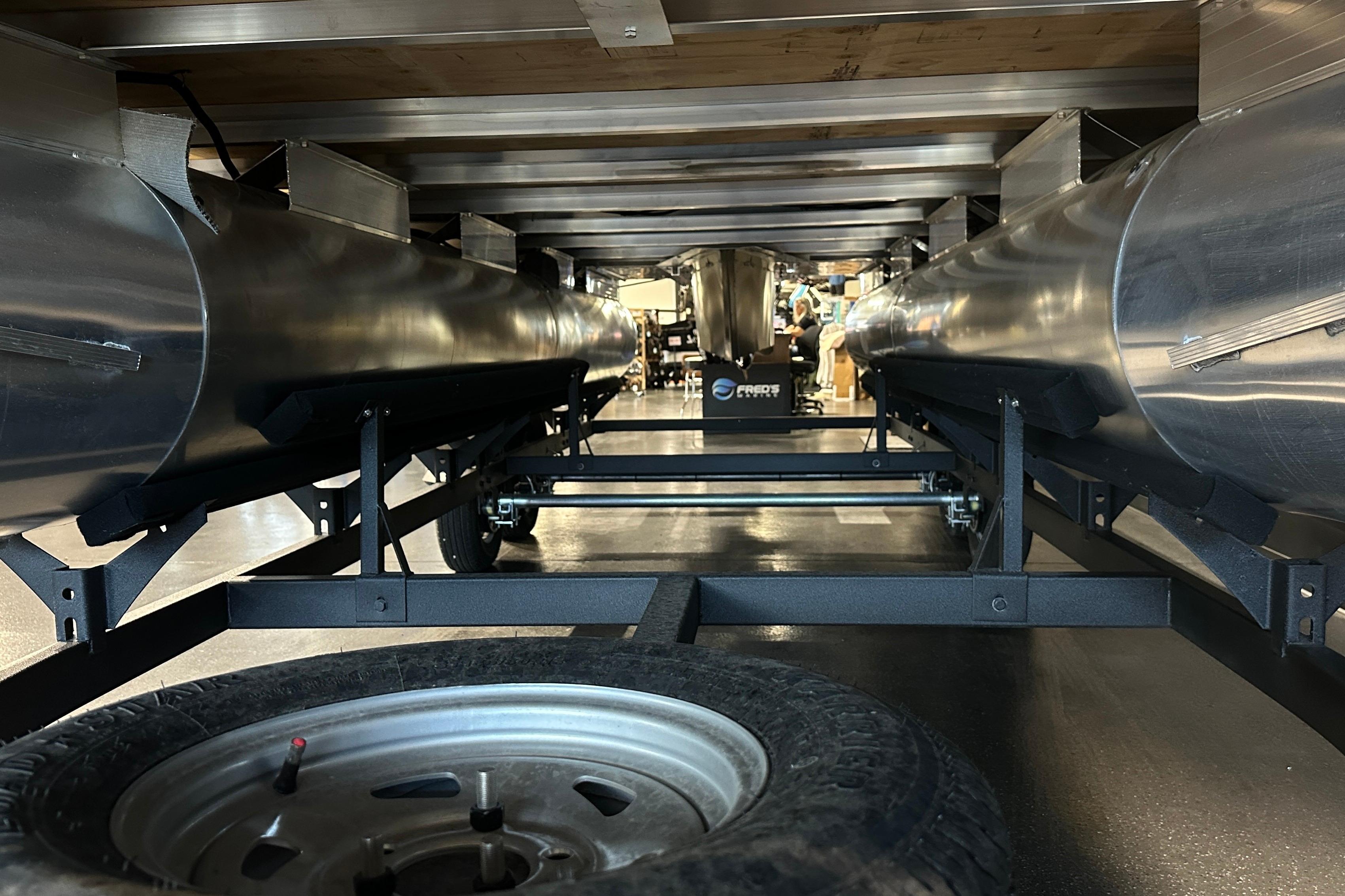 Underneath view of 2026 Sun Tracker SportFish 22 DLX pontoon boat on trailer.