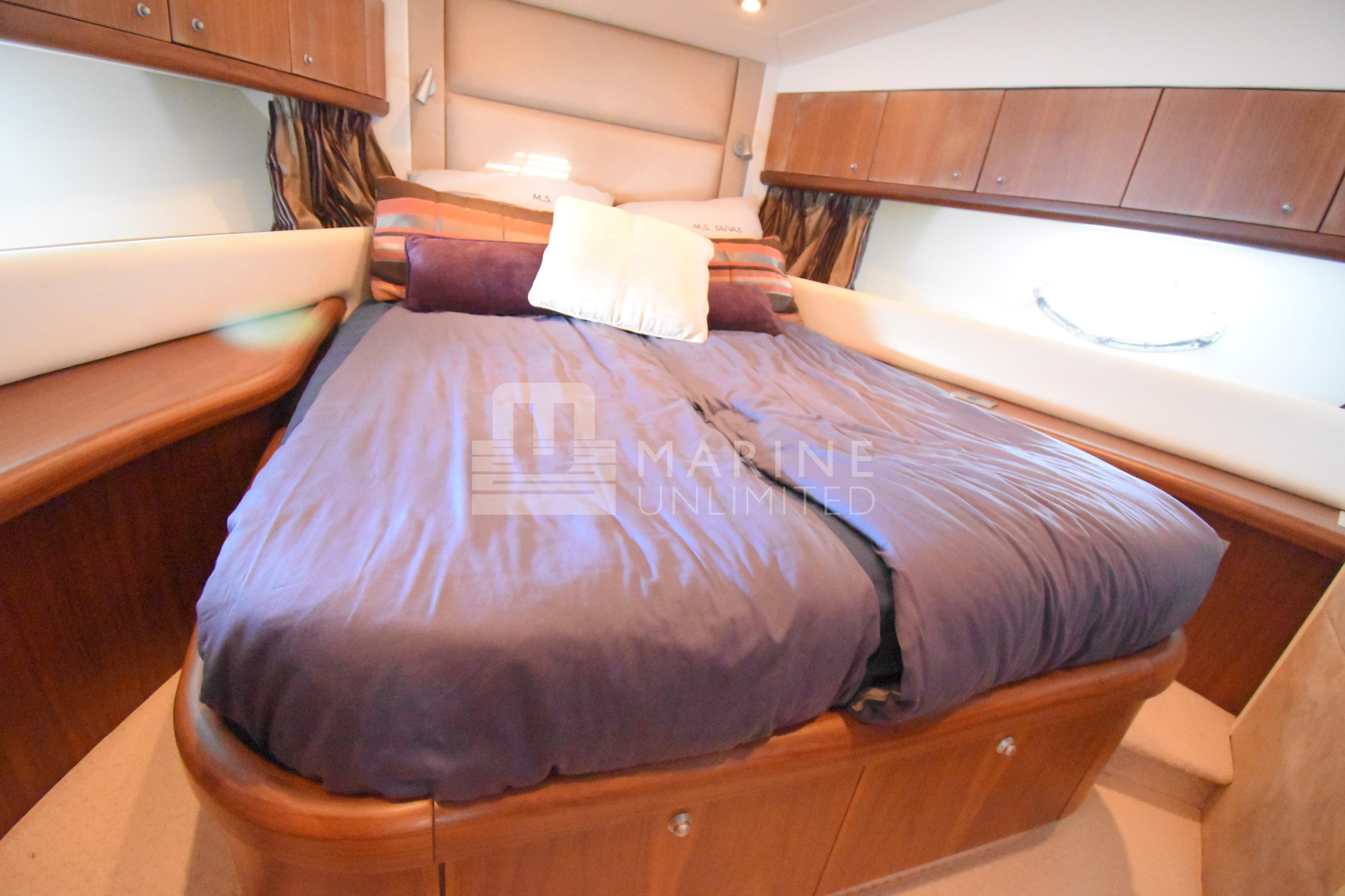 Luxurious cabin interior of 2010 Sunseeker Manhattan 52 yacht with cozy bed.