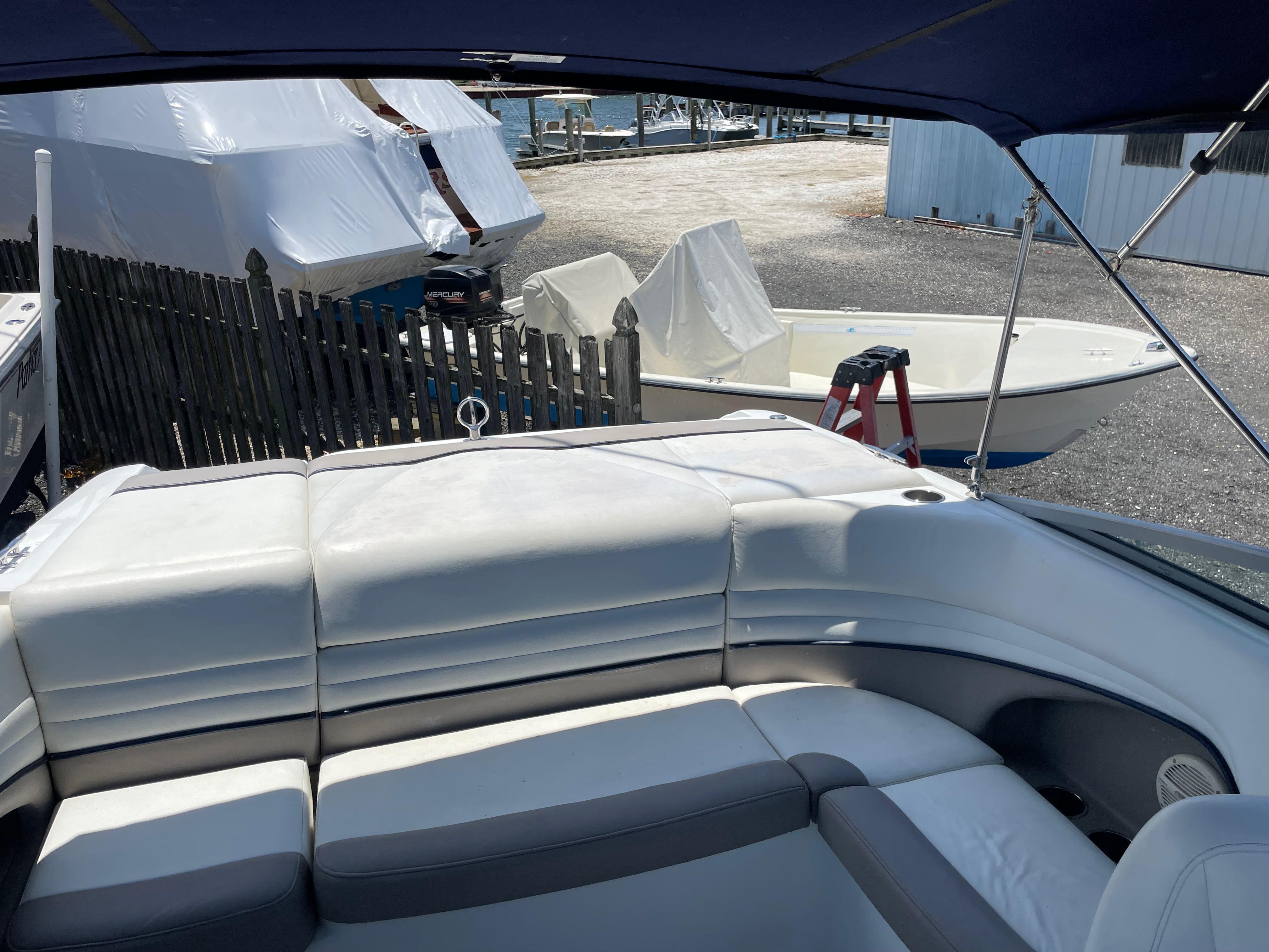 2004 Cobalt 226 boat interior with white leather seating, docked near covered boats.