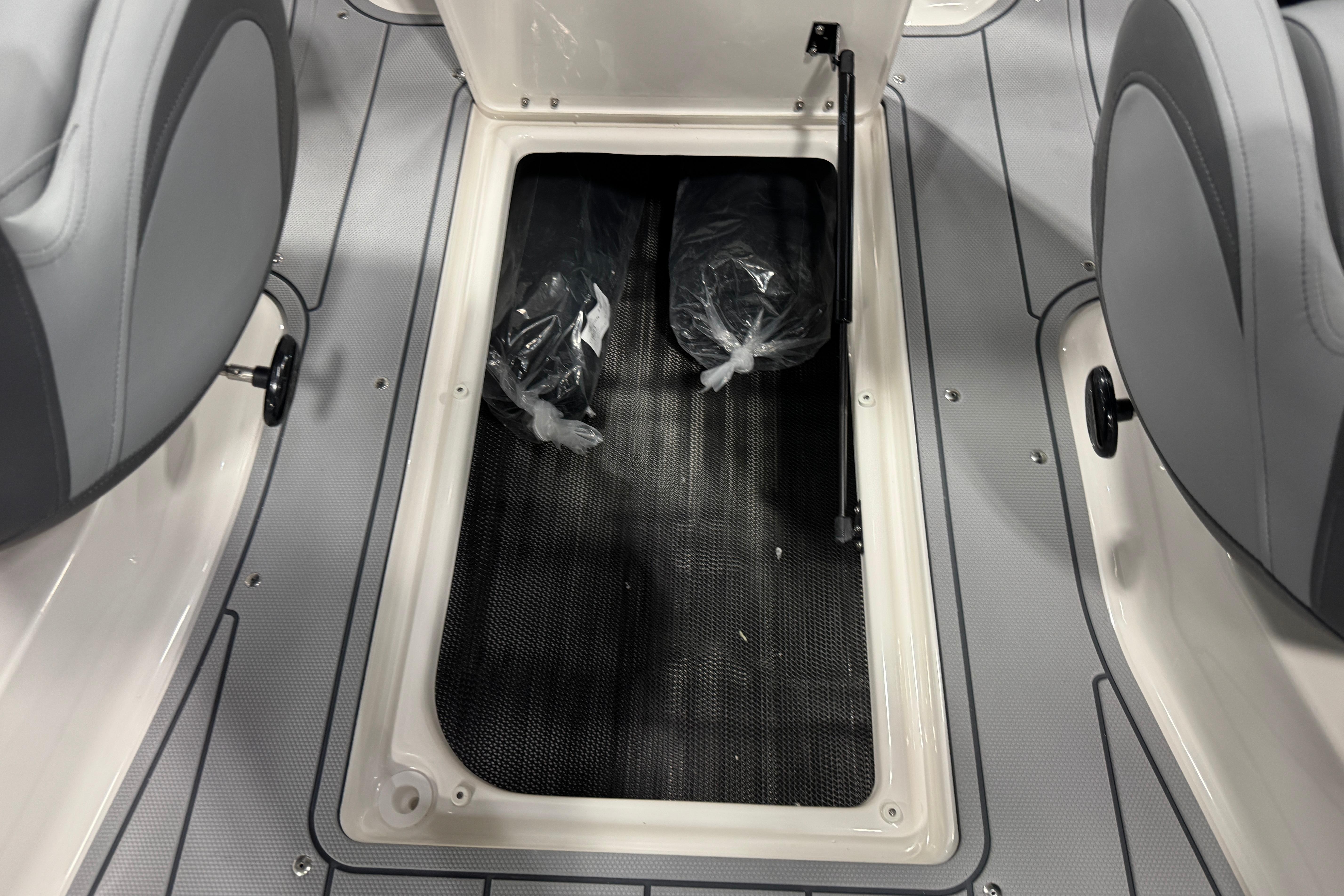 2026 Chaparral 23 SSi boat storage compartment with gray interior and seating.
