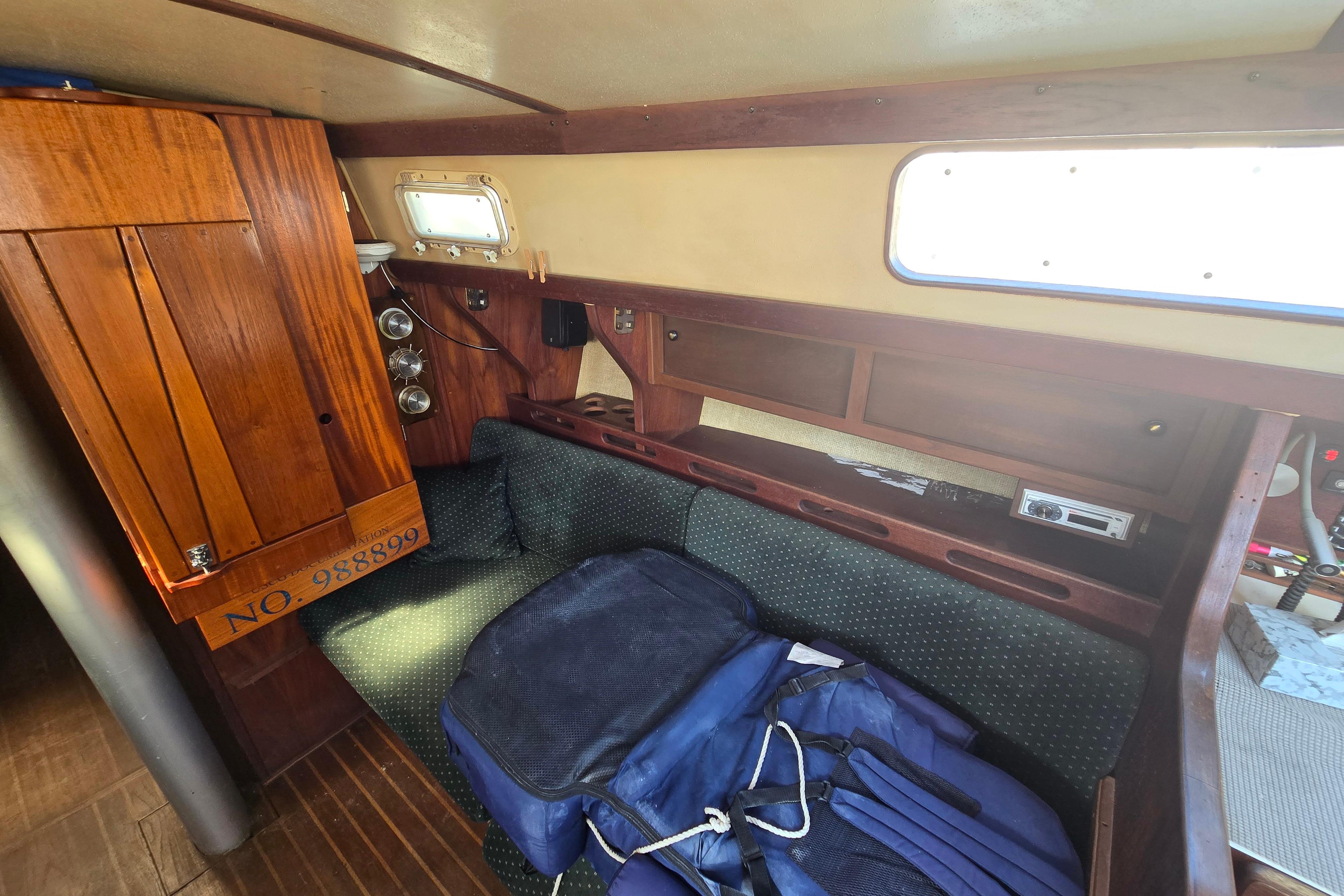 Interior of 1981 Morgan 321 sailboat with wooden cabinetry and cushioned seating.