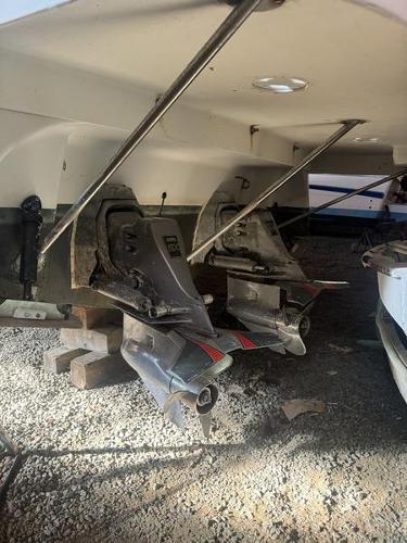 2005 Four Winns 298 Vista boat outdrives on gravel surface.