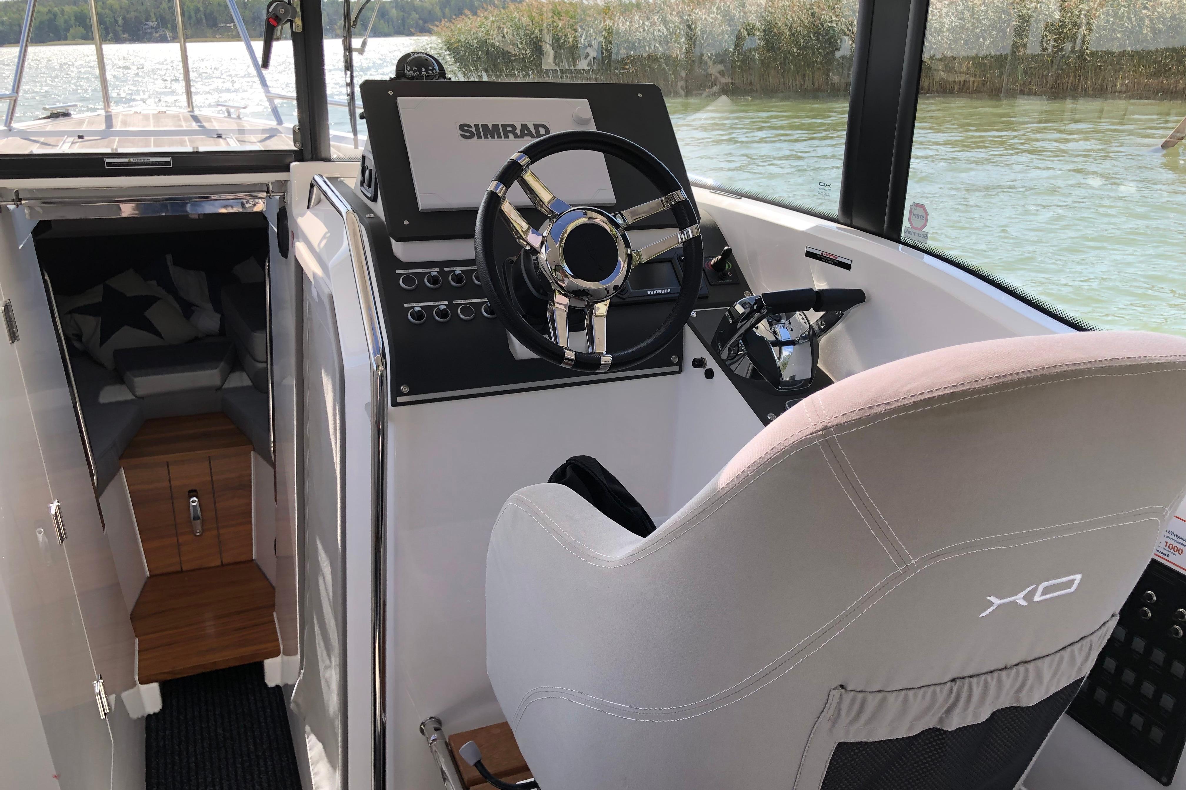 Interior of 2016 XO Boats 270 RS, featuring helm and cabin entrance.