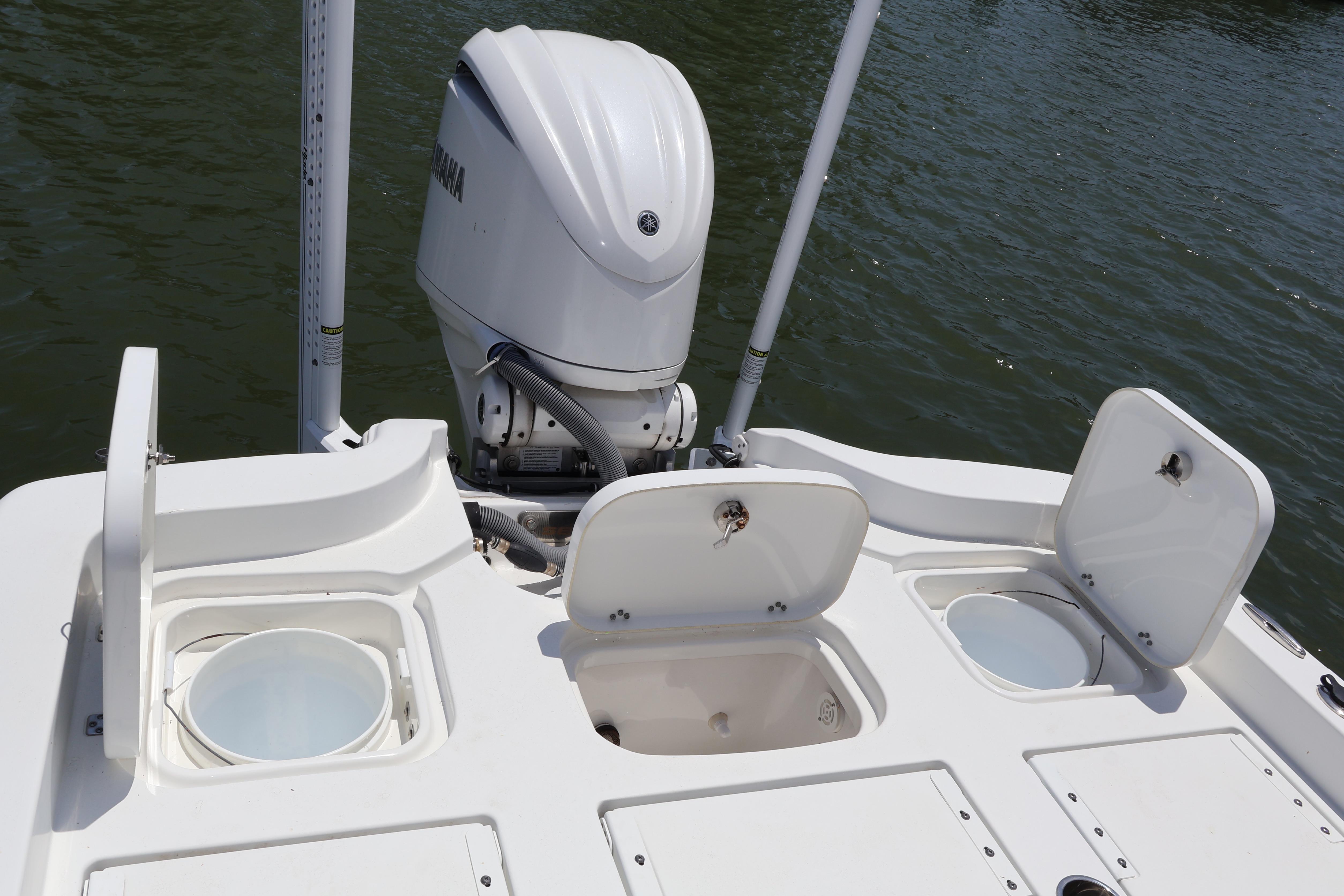 2022 Sea Hunt BX 25 FS boat with open storage compartments and Yamaha outboard motor.