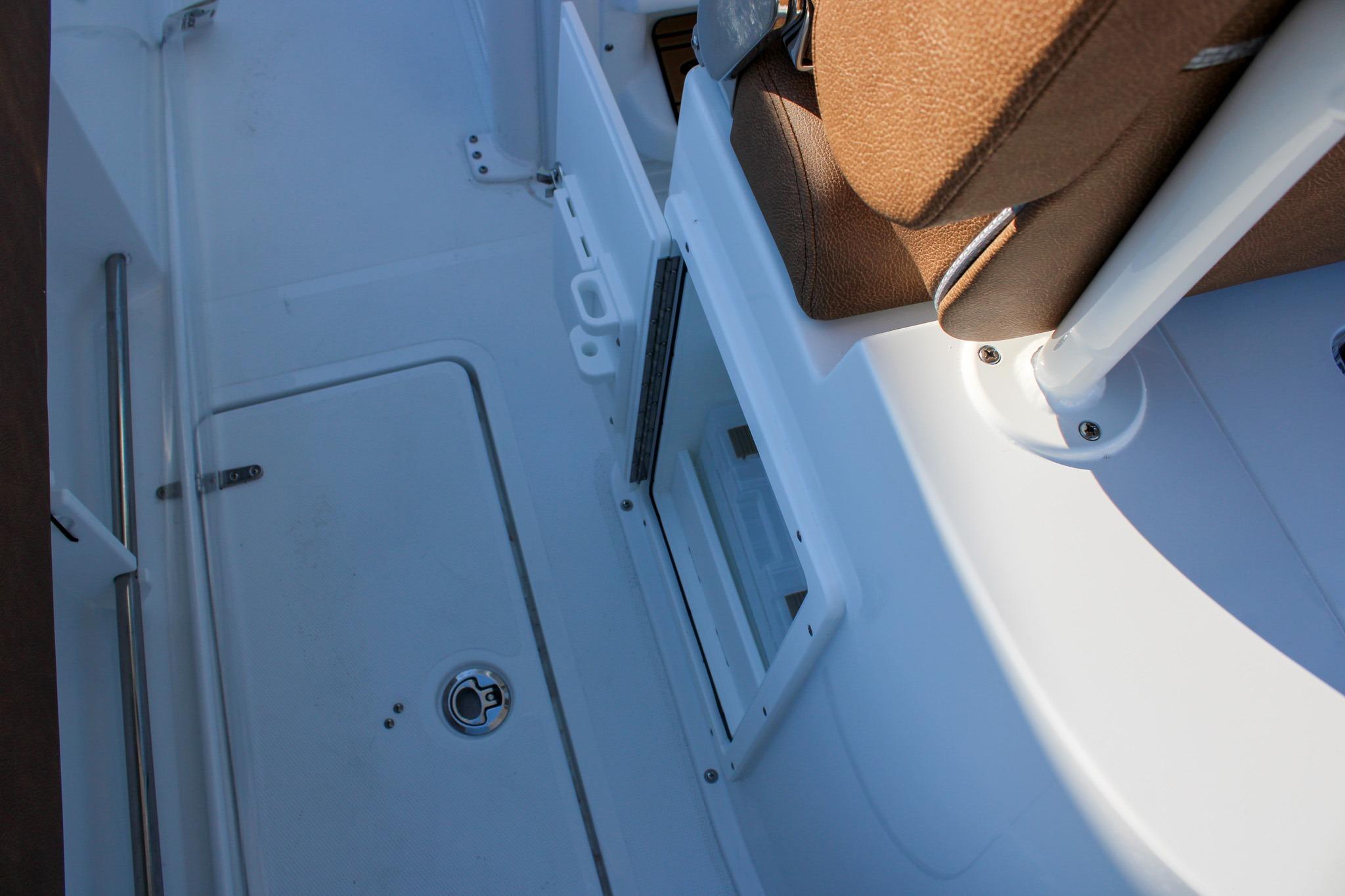 2026 Sea Hunt Gamefish 25 interior with brown seating and storage compartment.