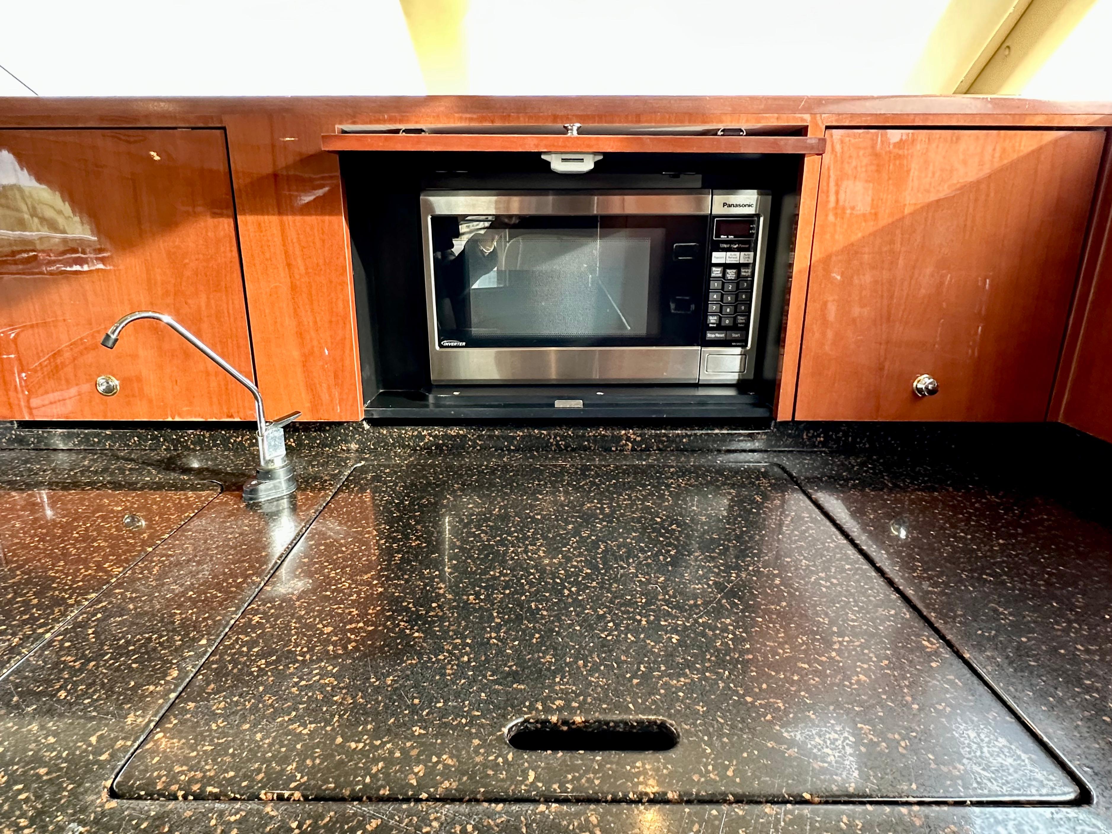 2002 Sea Ray 560 Sedan Bridge kitchen with microwave and sleek countertop.