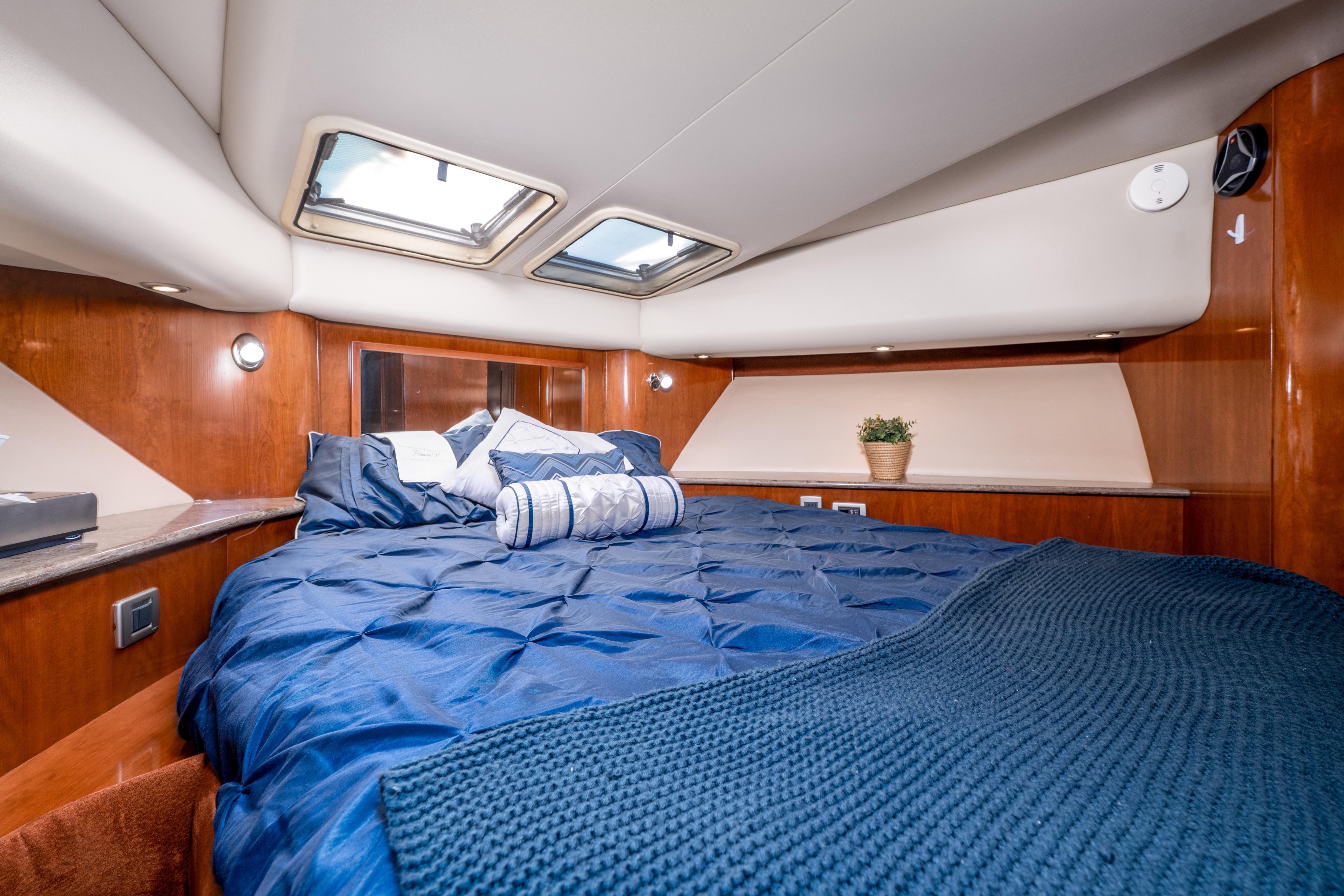 Luxurious bedroom in 2007 Meridian 580 Pilothouse yacht with skylights and elegant bedding.