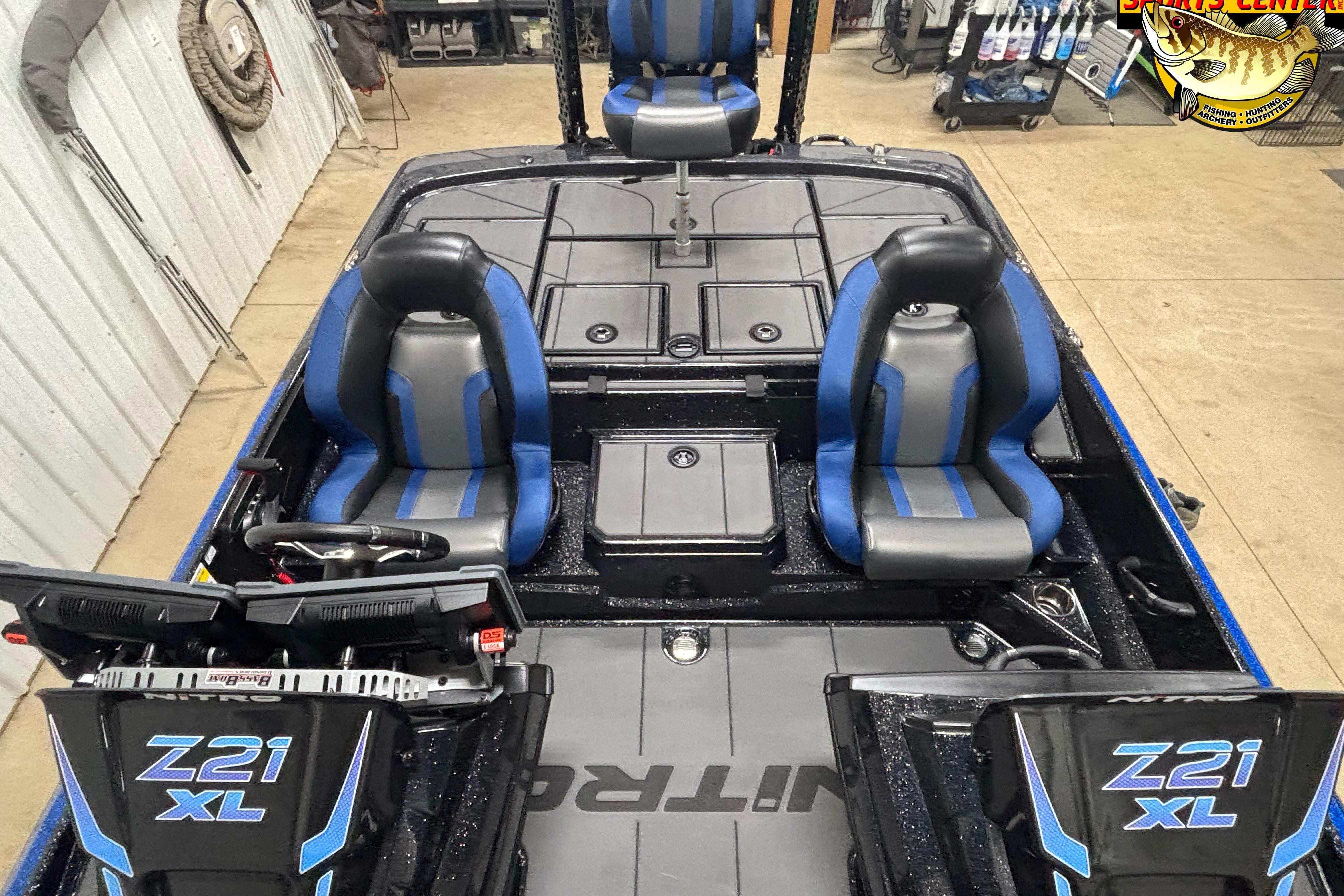 2026 Nitro Z21 XL boat interior with blue and gray seats, steering console, and storage compartments.