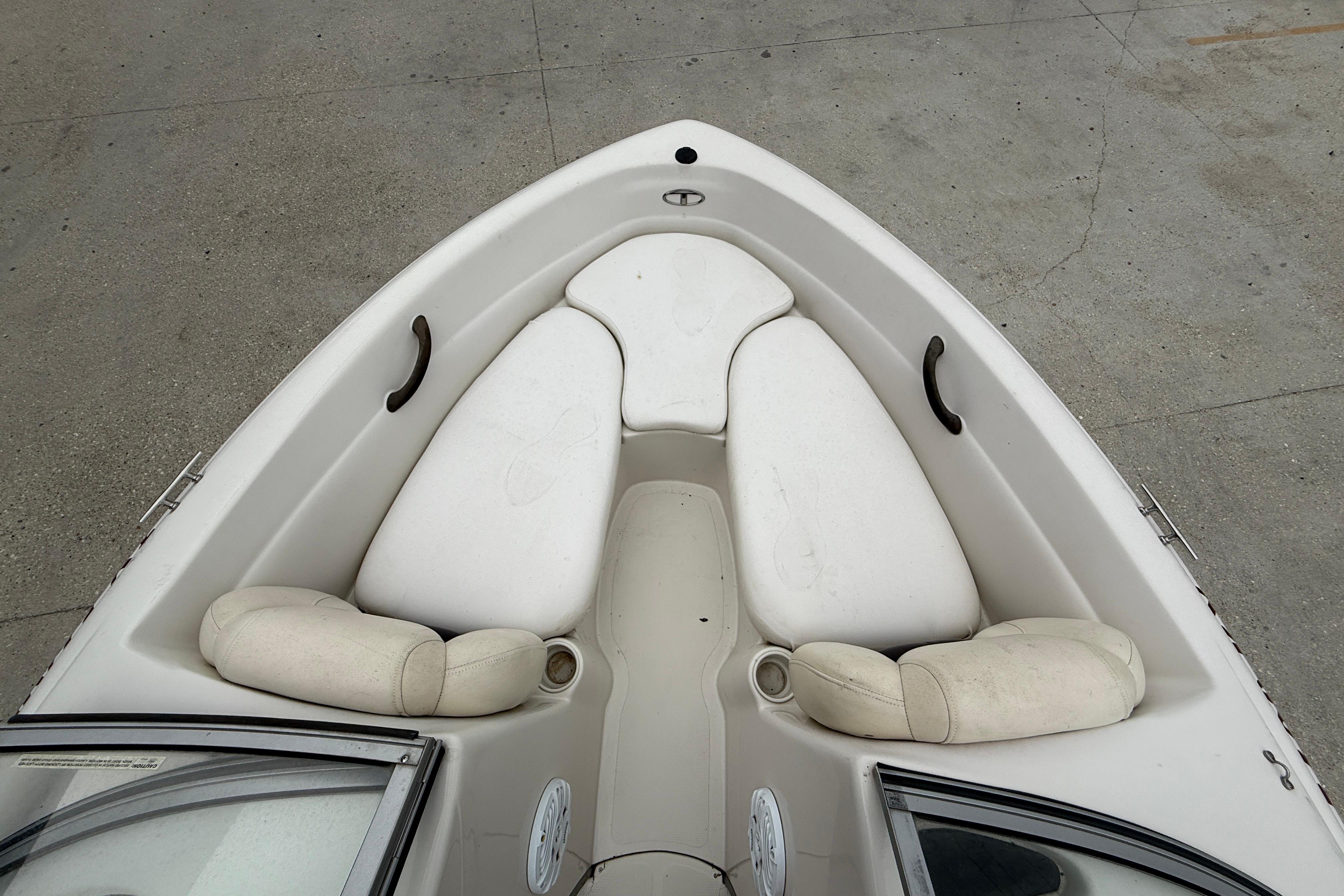 2010 Tahoe Q4 boat interior with white cushioned seating and cup holders.
