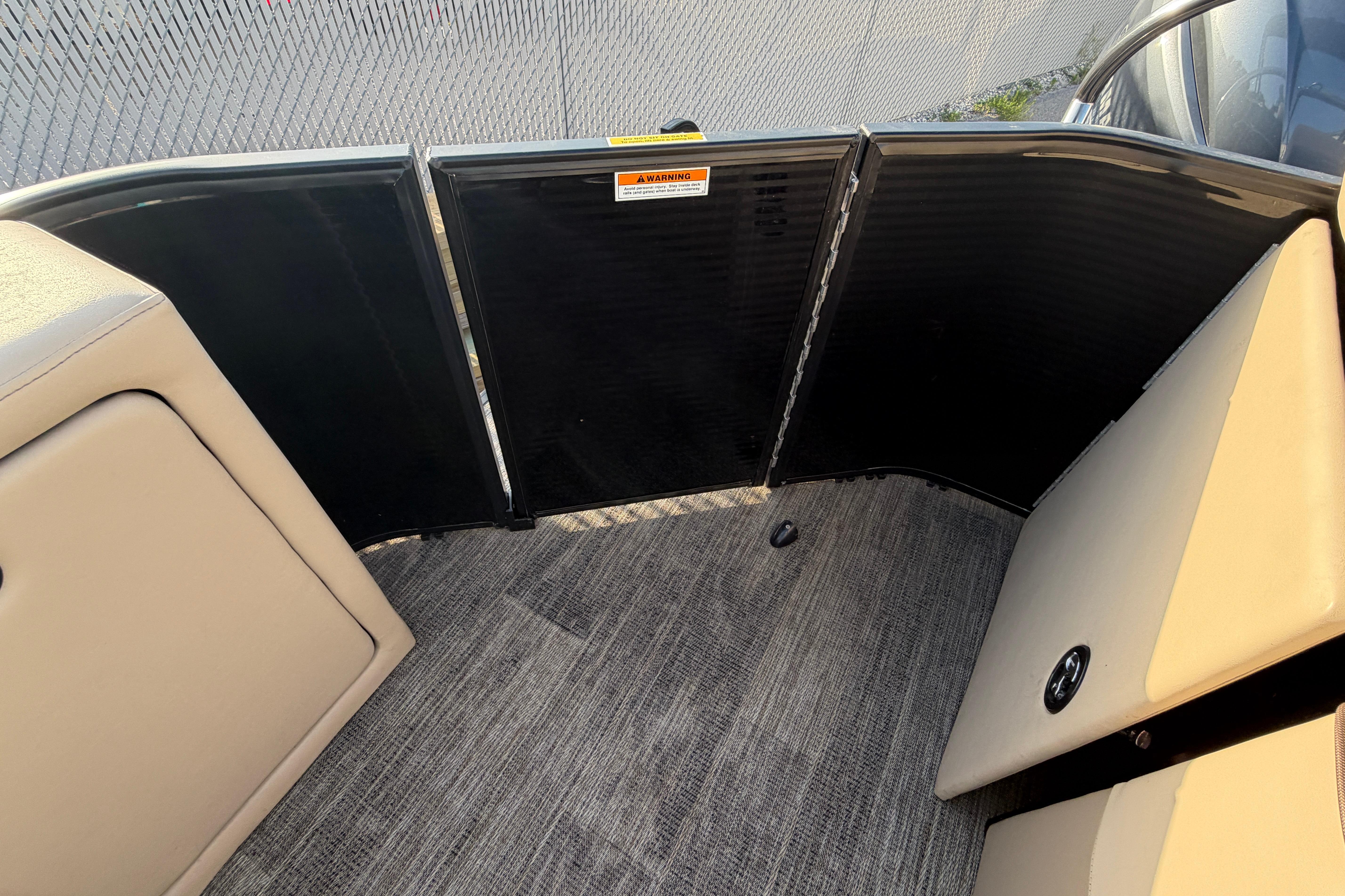 Interior view of 2023 Godfrey Sweetwater 2286 C pontoon boat with beige seating and carpeted floor.