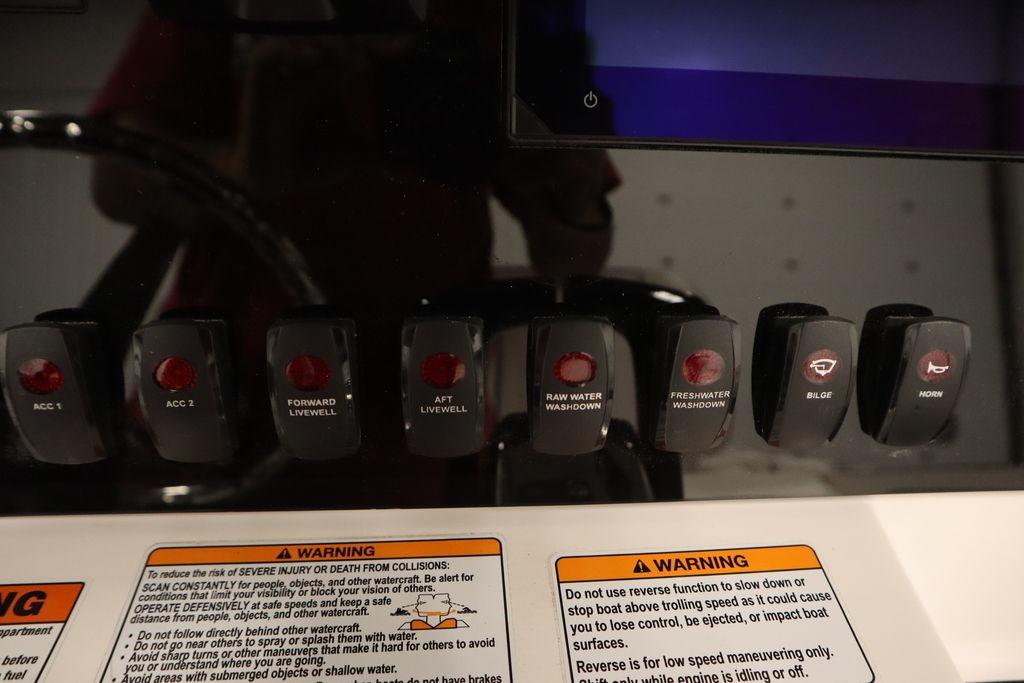 Control panel of 2026 Yamaha Boats 255 FSH Sport E with labeled switches and warnings.