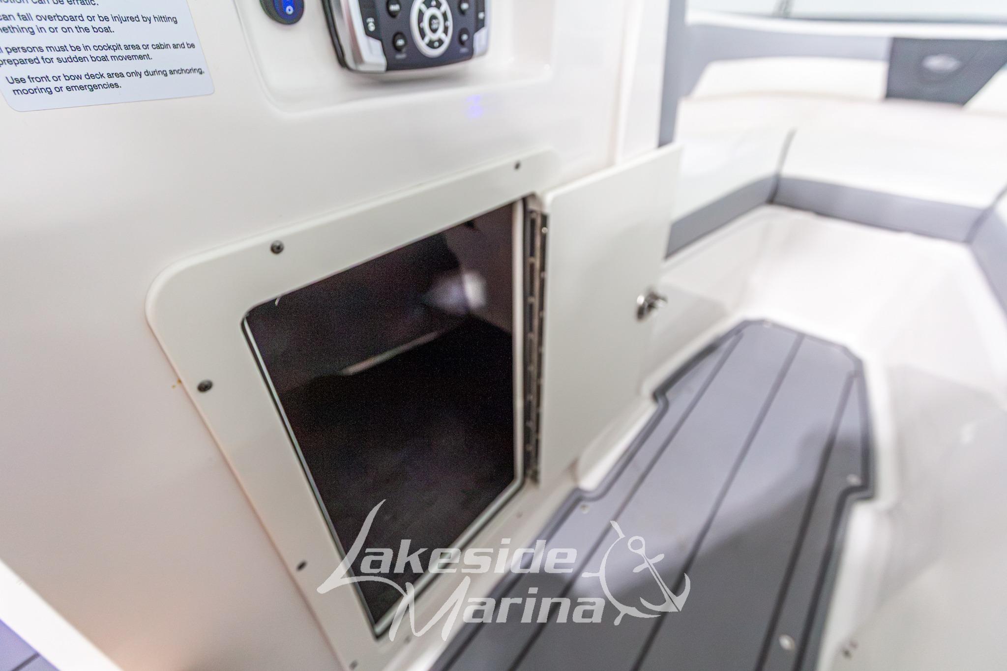 2022 Chaparral 21 SSi boat interior with open storage compartment and control panel.