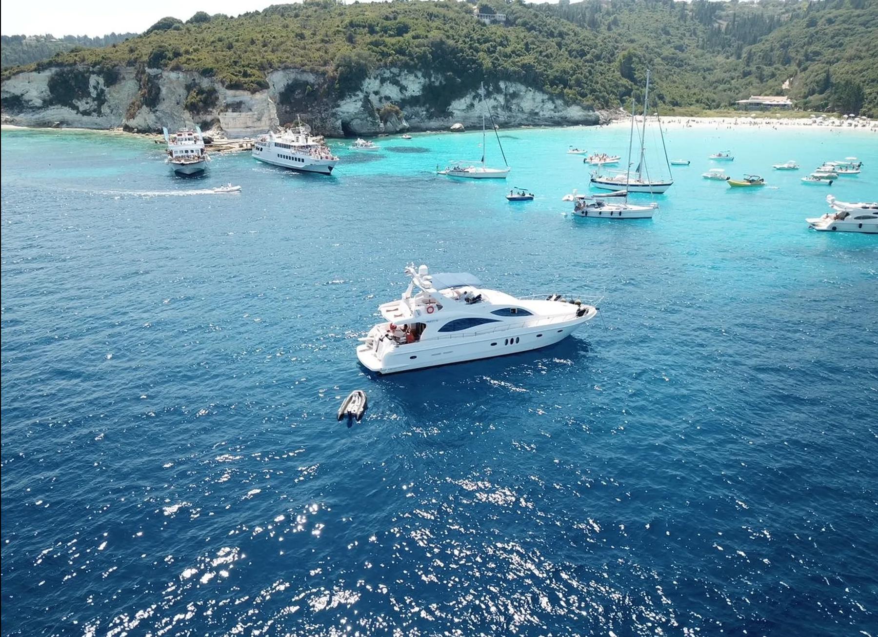 Majesty 66 Flybridge yacht on clear blue waters, surrounded by boats, 2010 model.