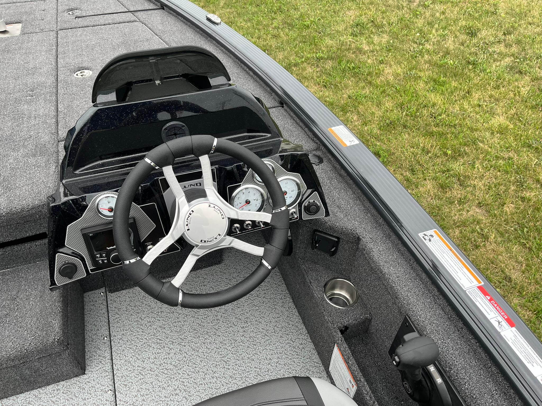 2026 Lund 1875 Pro-V Bass XS boat dashboard with steering wheel and gauges.