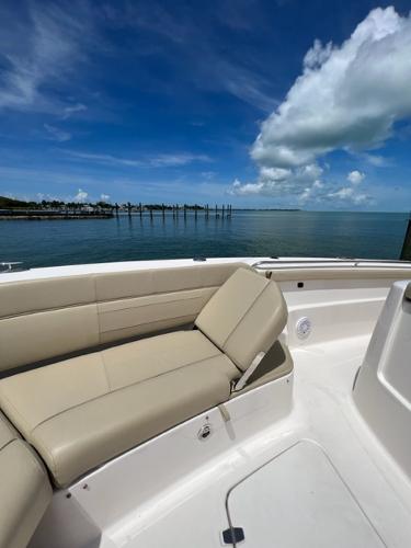 2019 Pursuit S 408 Sport boat with beige seating, ocean view, and blue sky.