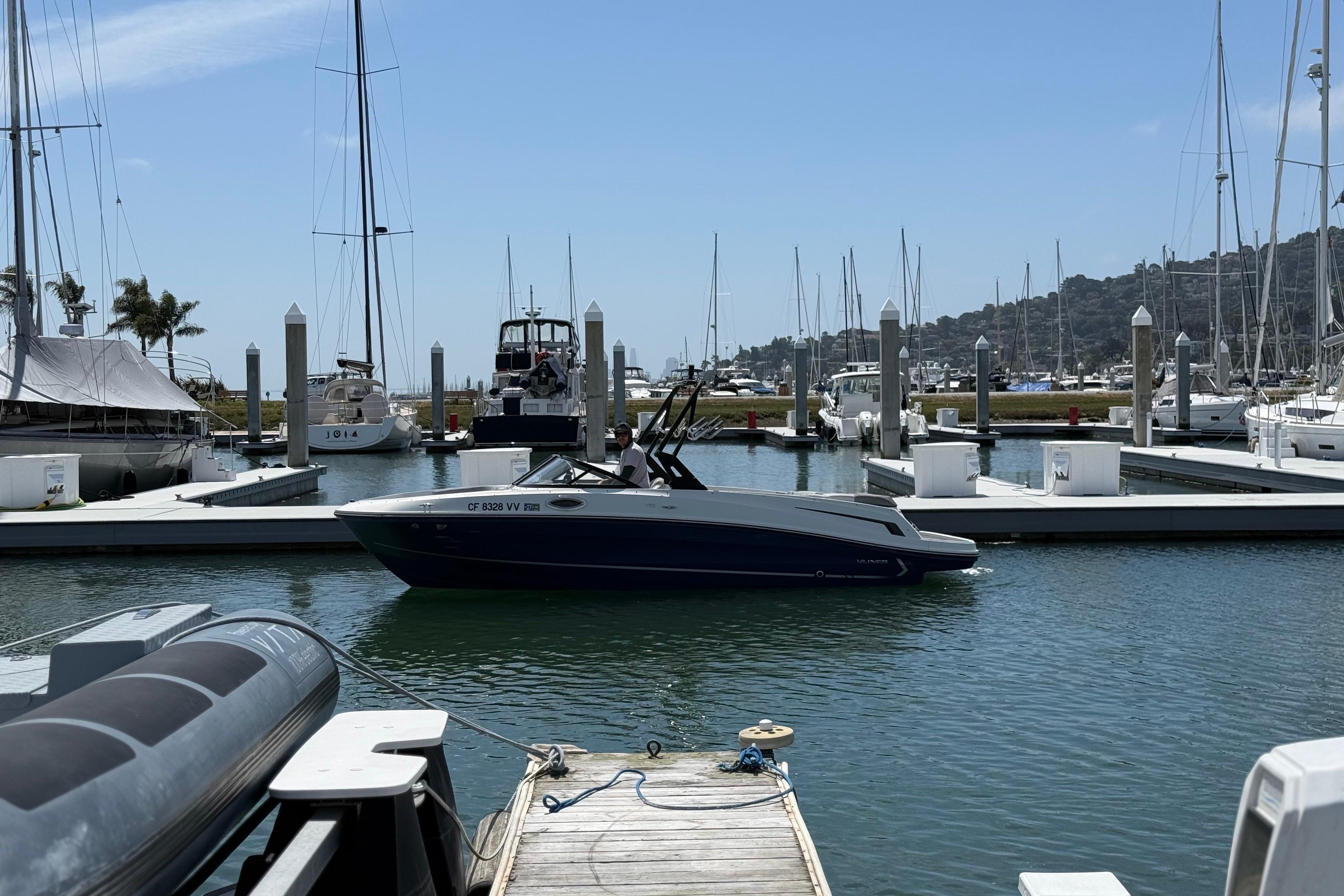 2021 Bayliner VR5 Bowrider I/O docked at a marina with sailboats in the background.