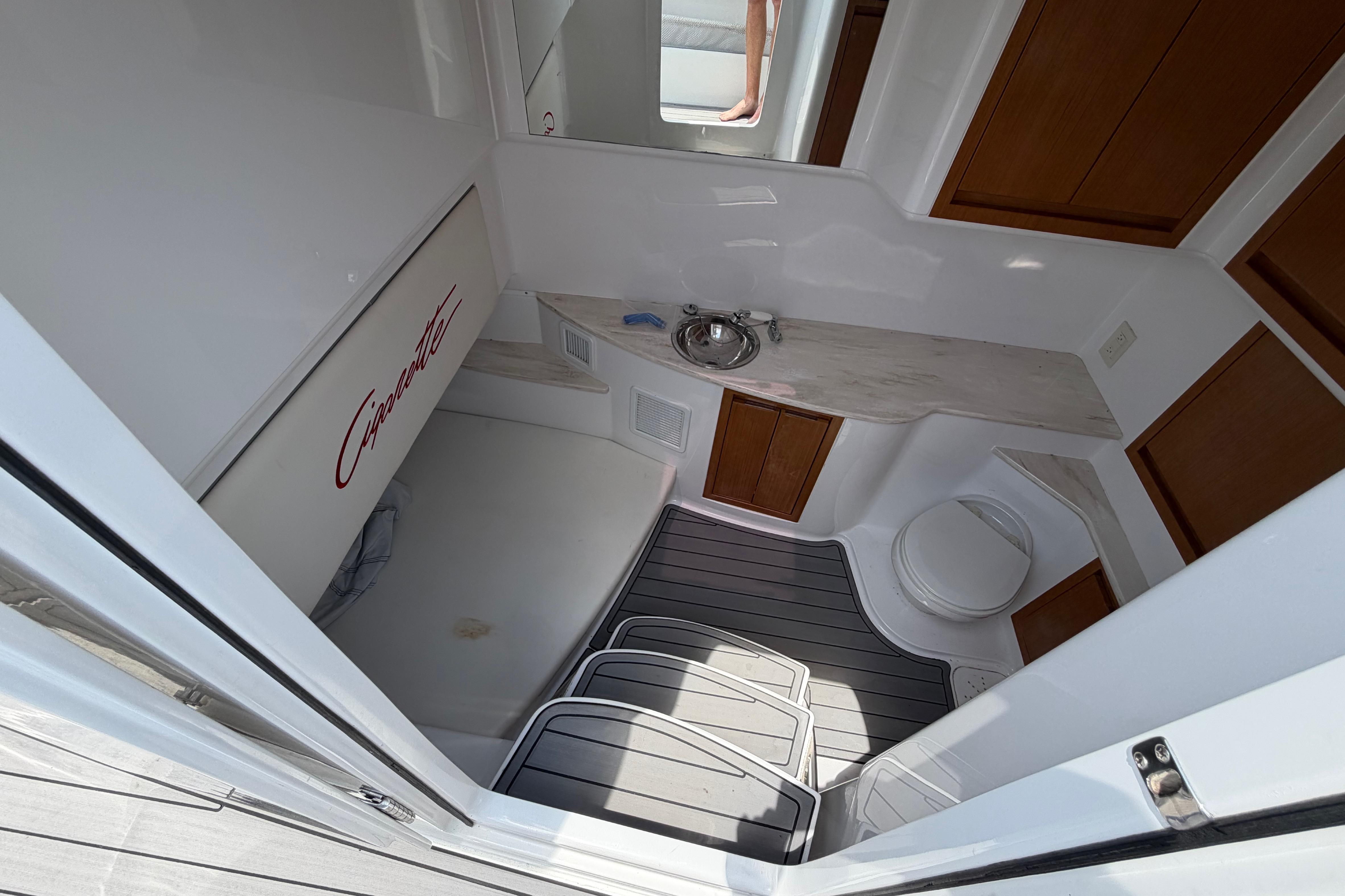 Interior of 2015 Cigarette 41' Nighthawk SD Edition boat, featuring a compact bathroom.